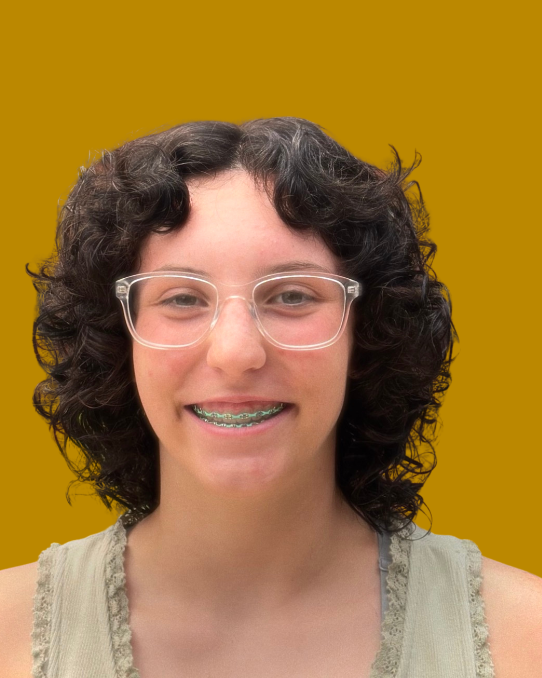 person with glasses and cropped curly hair smiles at camera