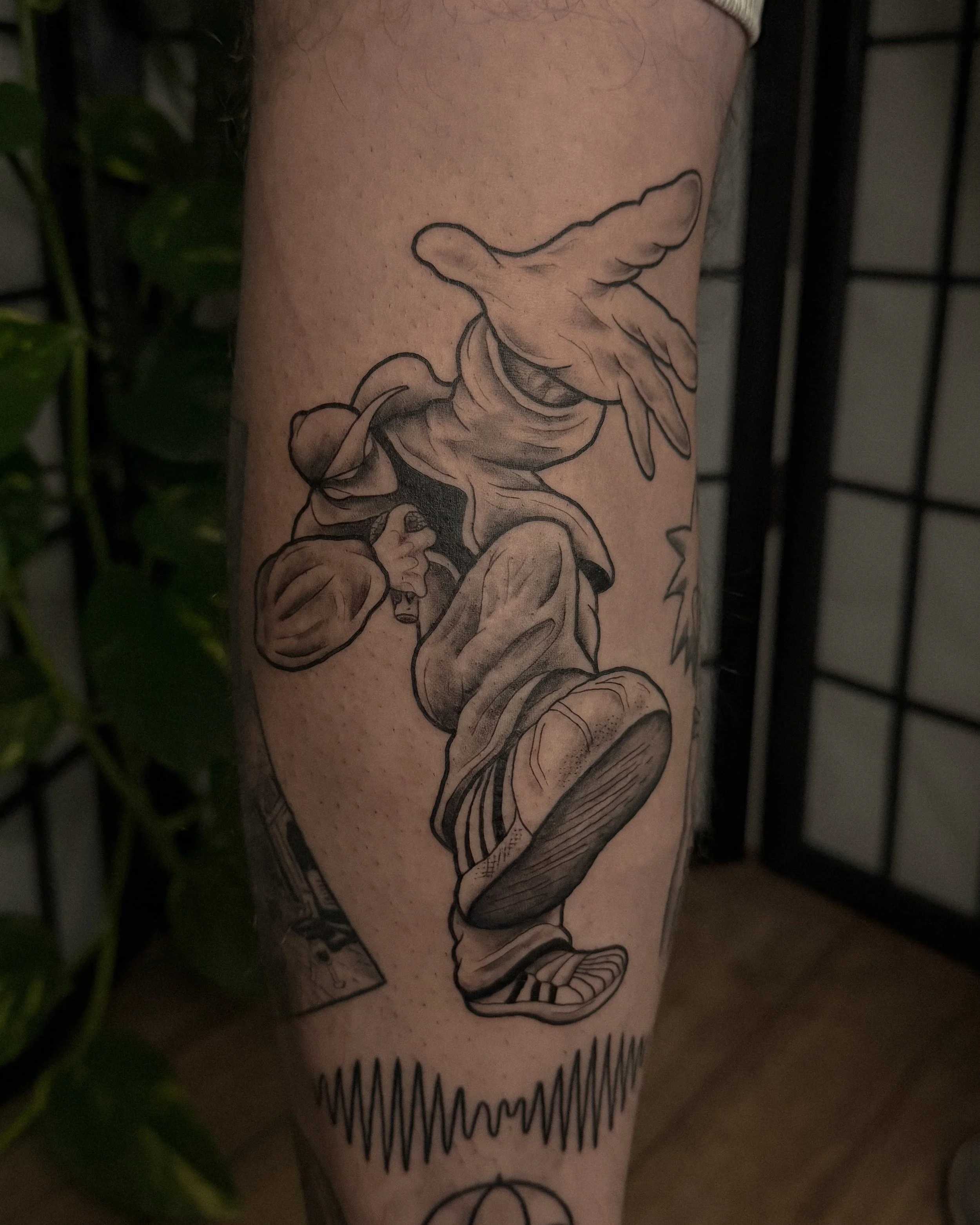 A tattoo of a praying angel on a person's leg, with detailed shading and line work.