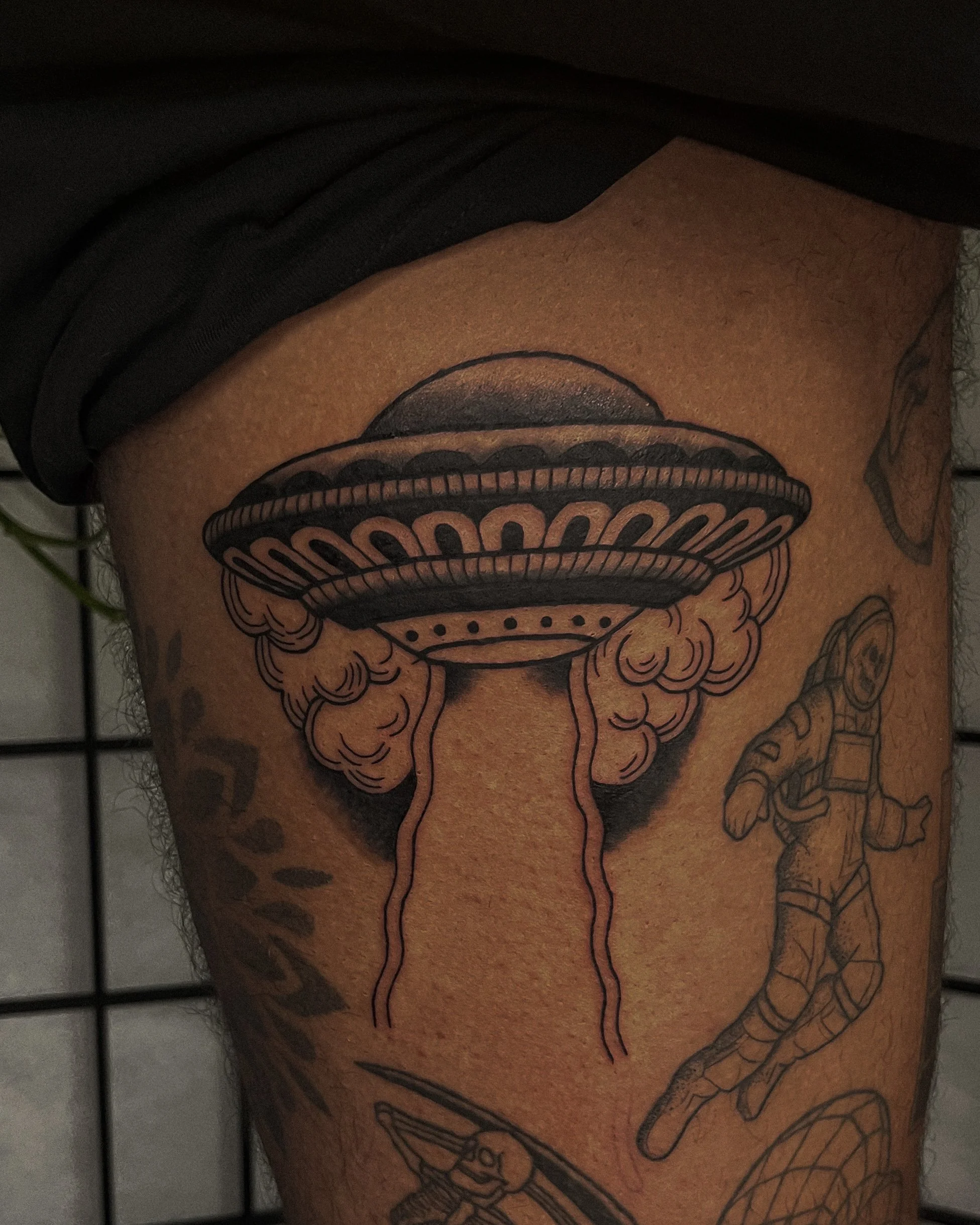 Tattoo of a stylized mushroom cloud on a person's skin, with black ink and detailed line work.
