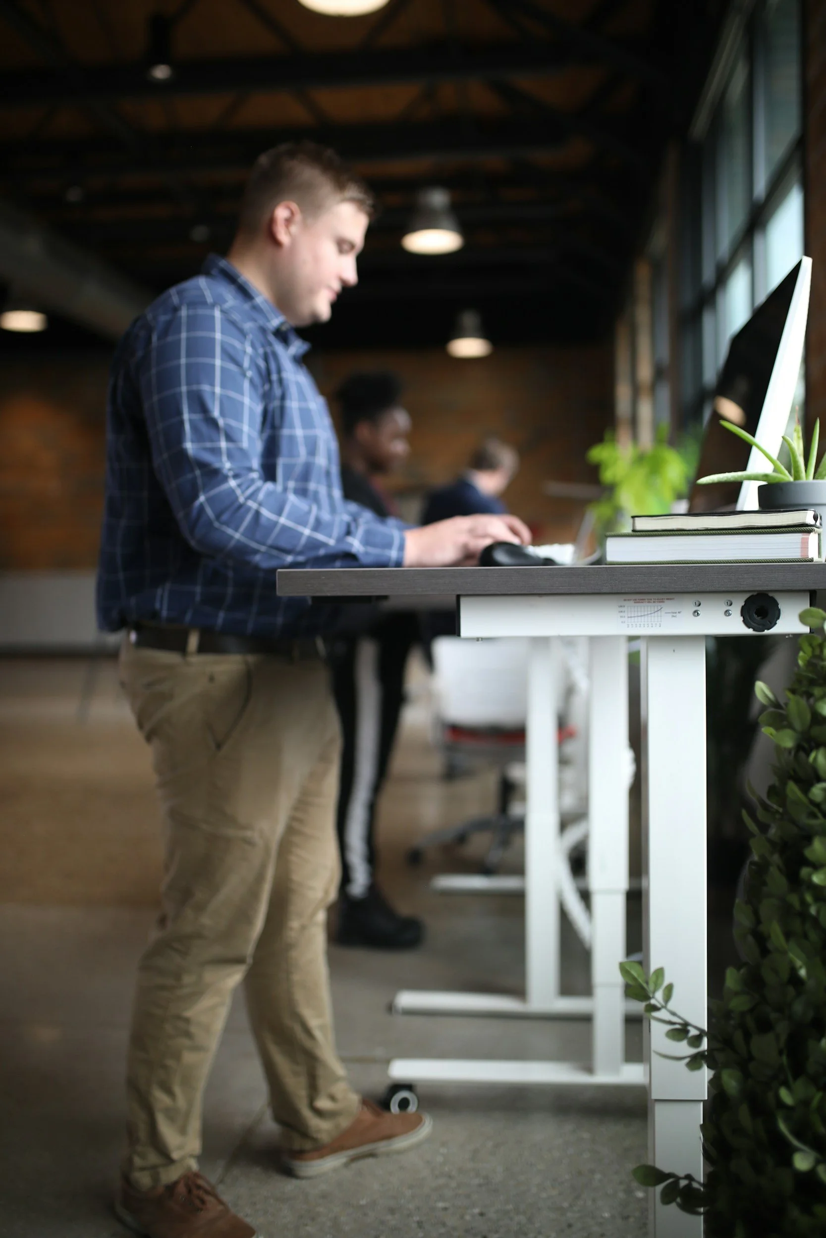 Sit stand desk with man at PC