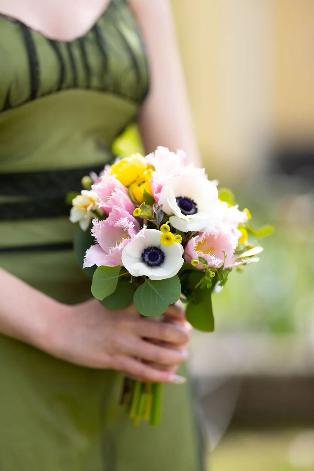 A bridesmaid holding a petite bouquet. 