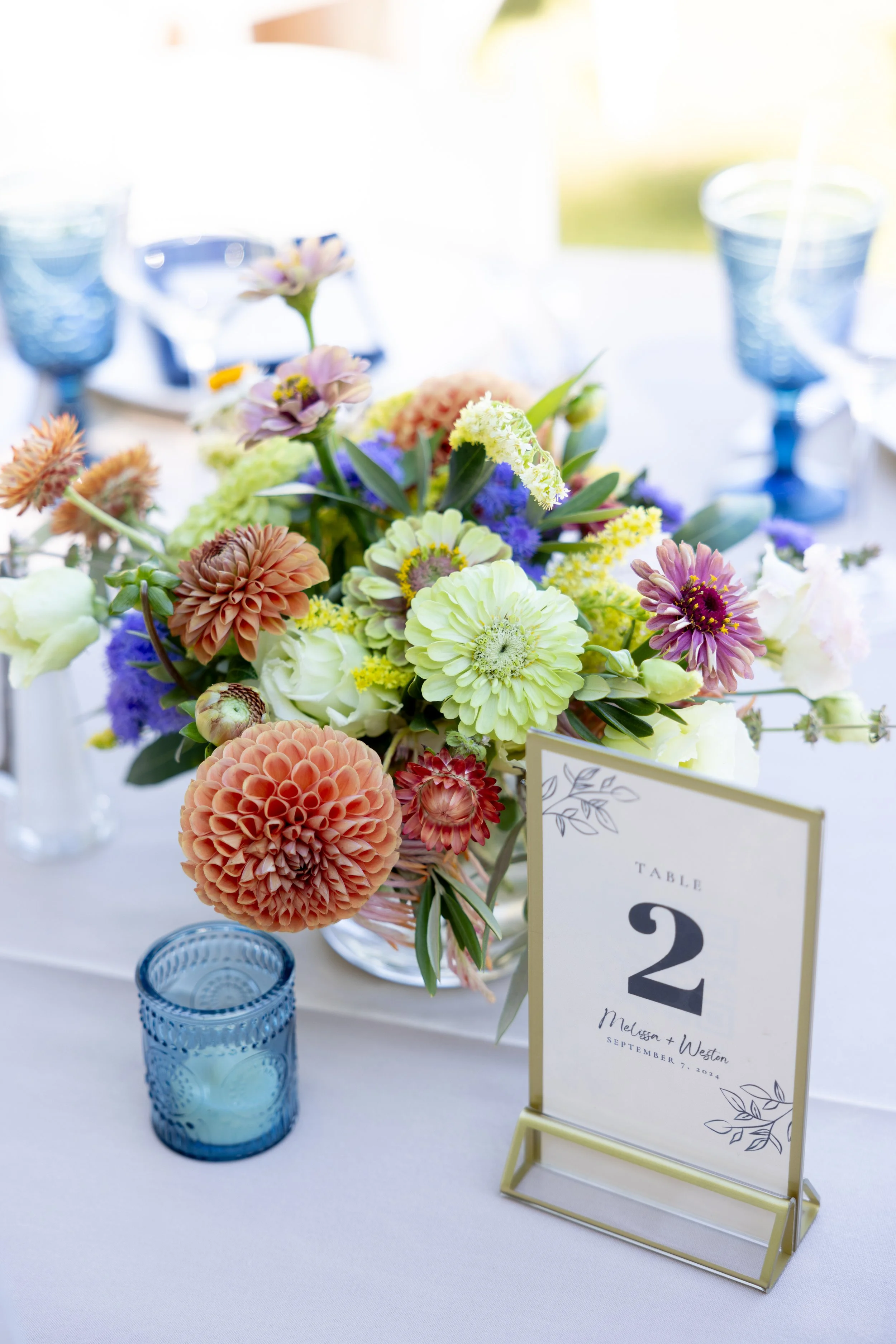 Vine Hill House floral centerpiece with blue votives and glassware