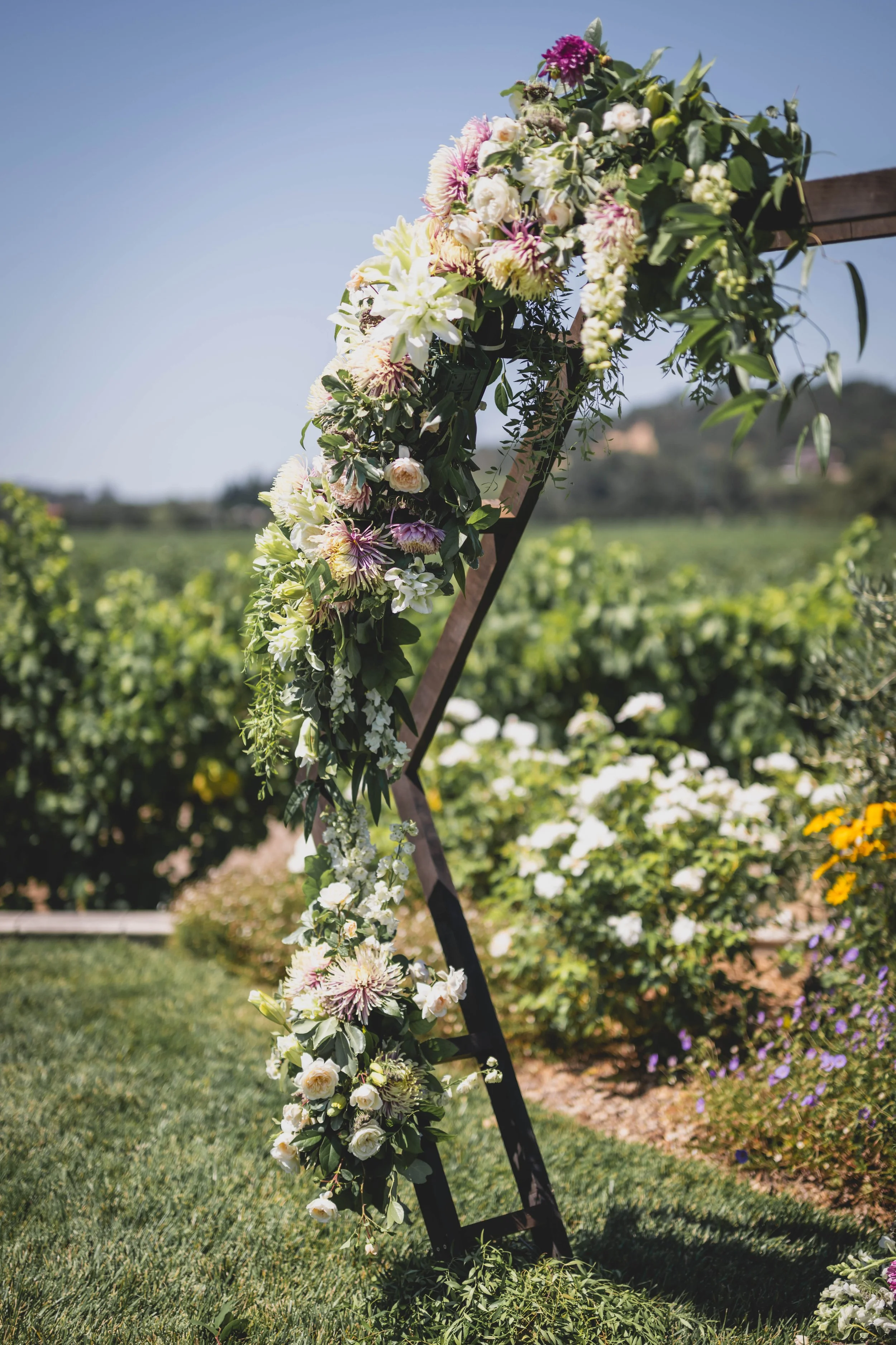 Hexagon arch with local flowers in whites, green and dusty rose