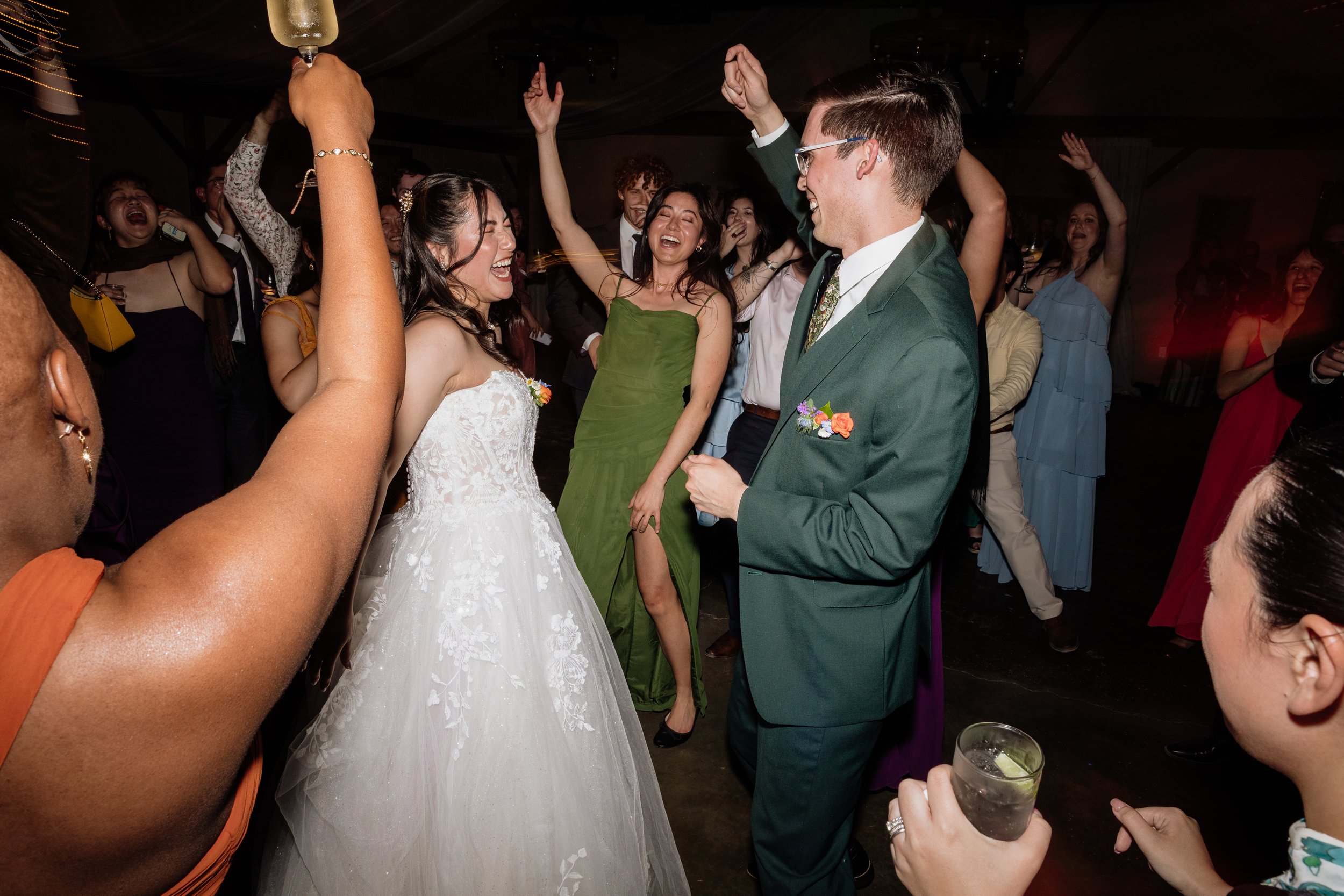 Bride and groom dancing with guests inside the barn reception space at The HIghlands Estate wedding venue in Cloverdale, California.