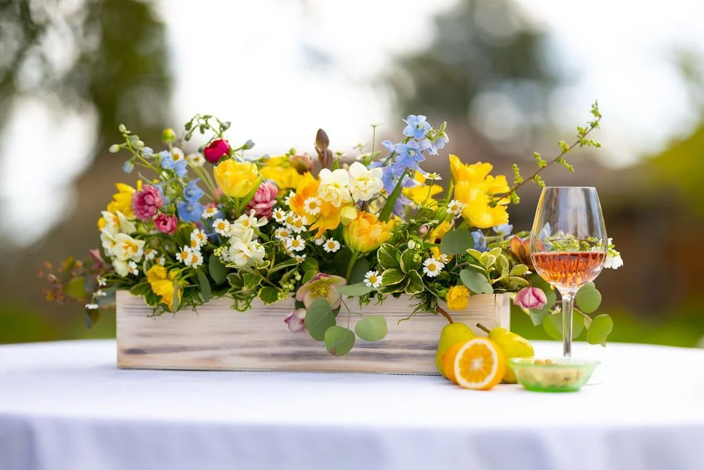 Seasonal Sonoma wedding flower centerpiece with bright garden flowers on outdoor table setting
