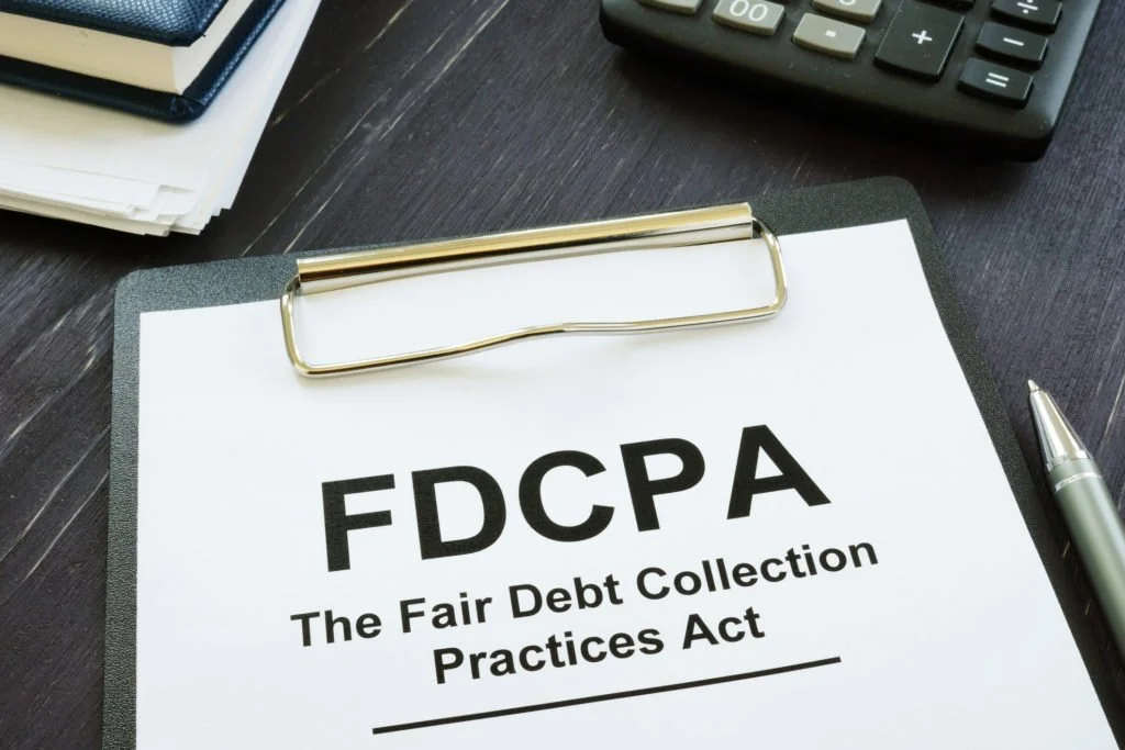 FDCPA document on clipboard with calculator and pen on table