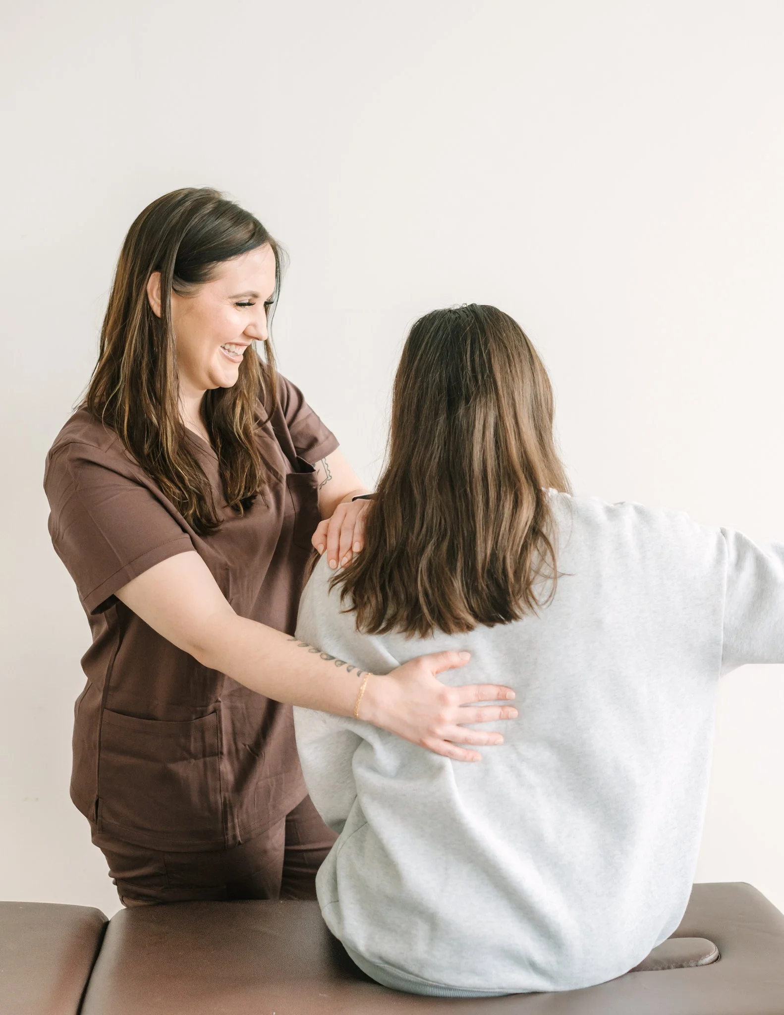 A healthcare professional examining a patient's shoulder during a consultation.
