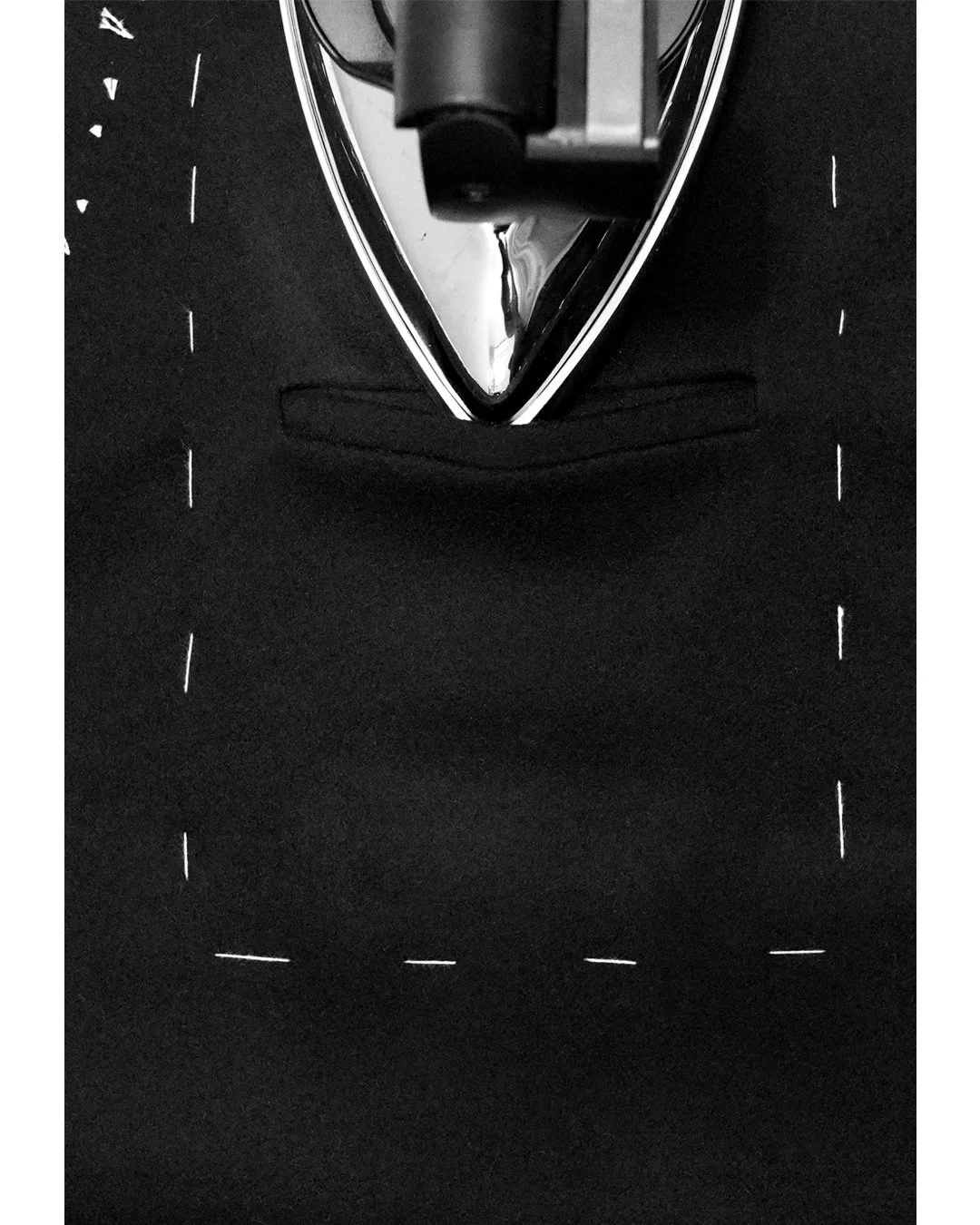 Lafóa Studio - Behind the scenes of a tailoring studio - A photograph of a iron pressing a welt pocket.