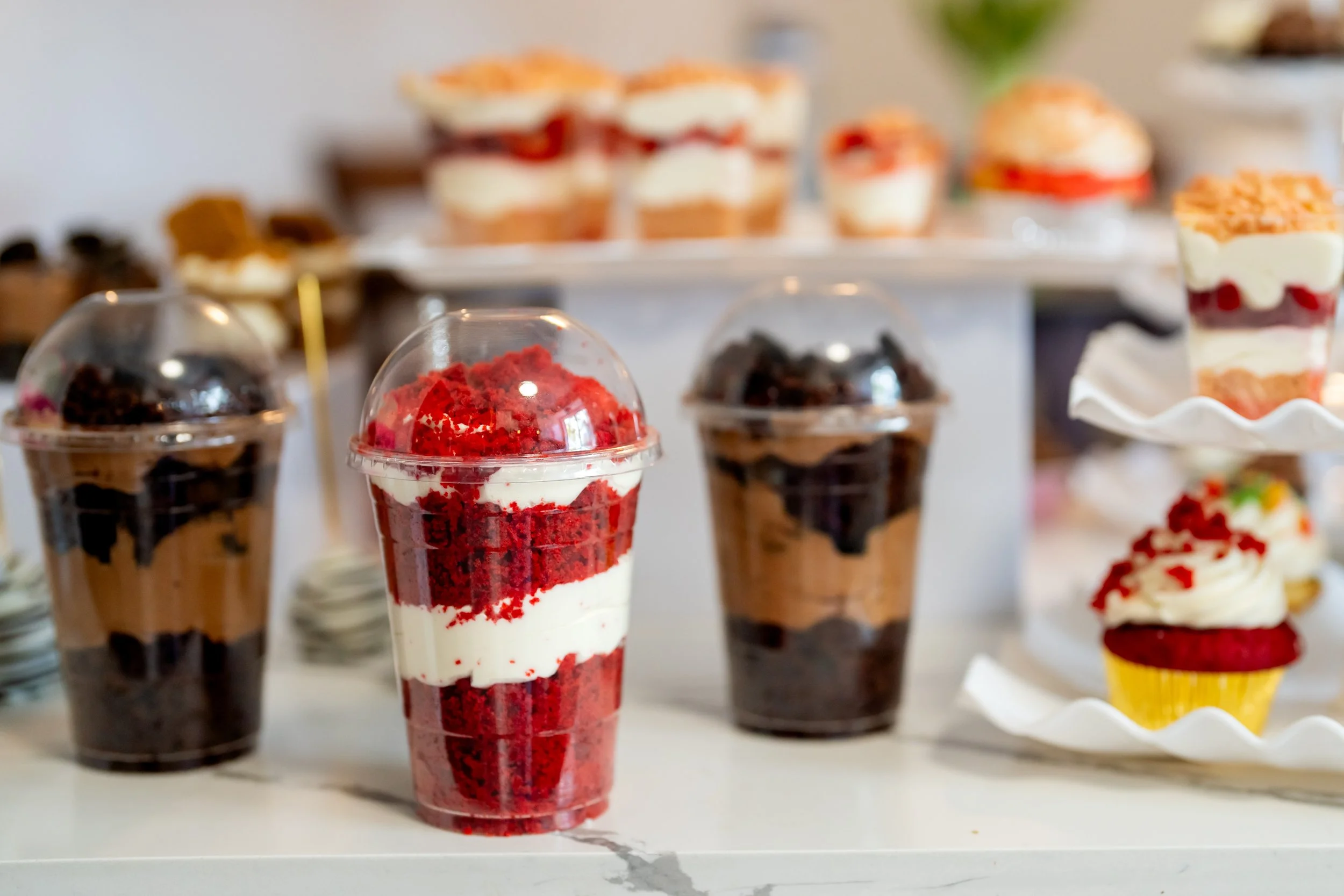 Red velvet and chocolate cheesecake cake jars in plastic to-go containers