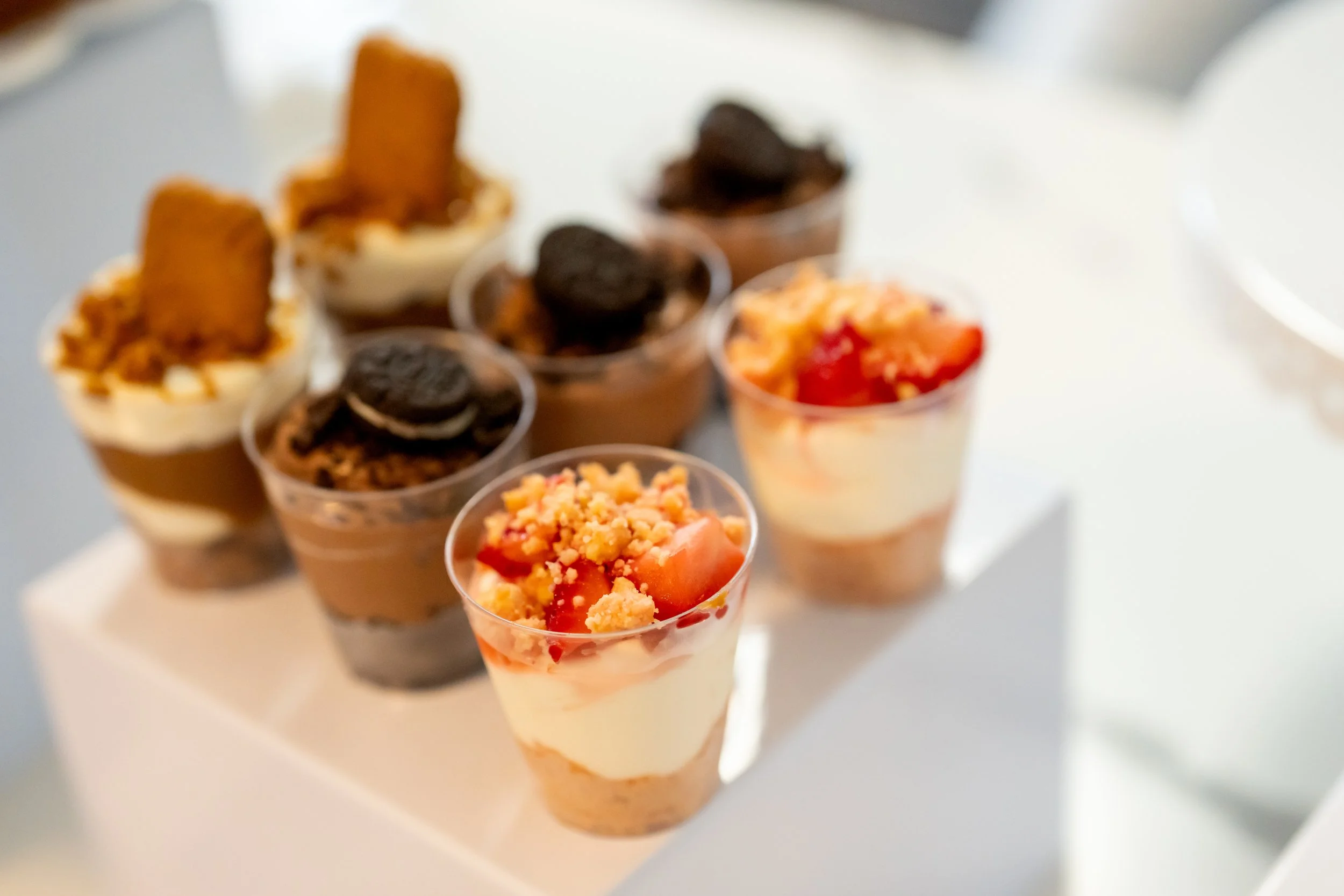 Assorted cheesecake cake jars on a white pedestal