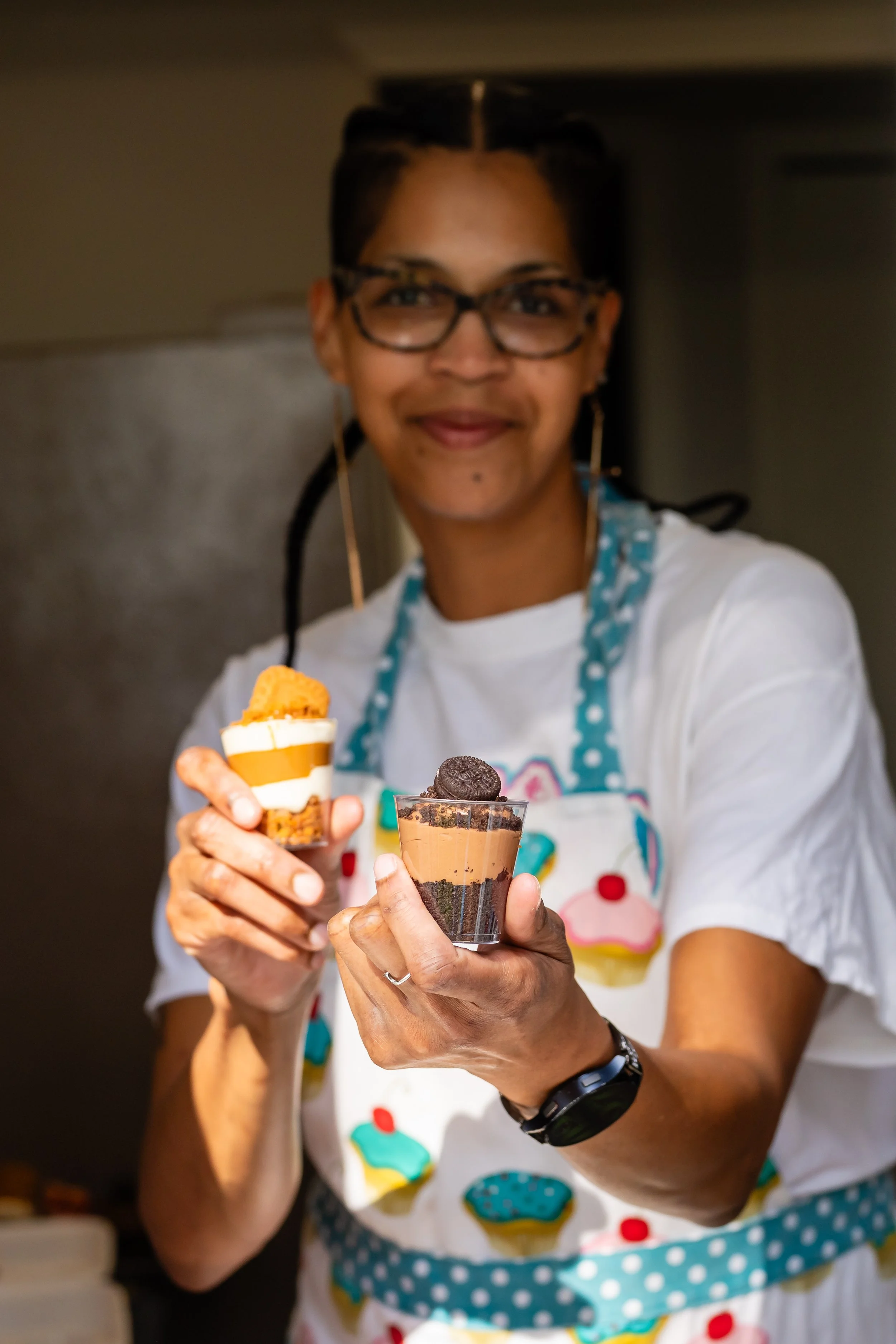 Danielle Jackson holding two types of cheesecake parfaits