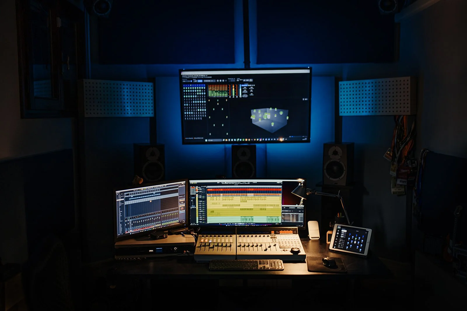 Studio di registrazione con monitor, console di missaggio e attrezzature audio.