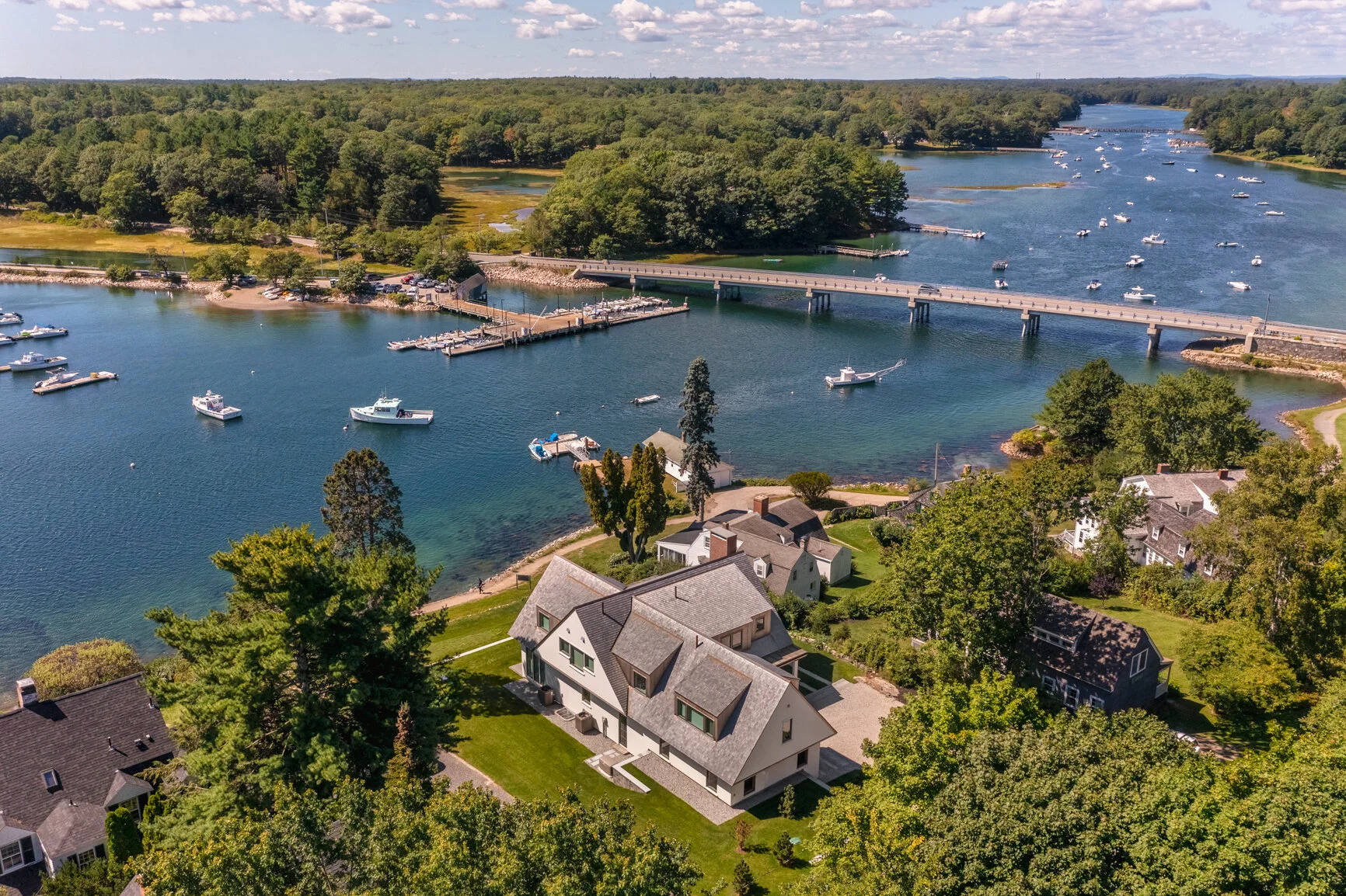 An aerial perspective of a custom waterfront residence designed by Lindsey Architects, thoughtfully integrated into the Maine coastal landscape with sweeping harbor views and direct connection to the surrounding shoreline. This luxury home reflects a