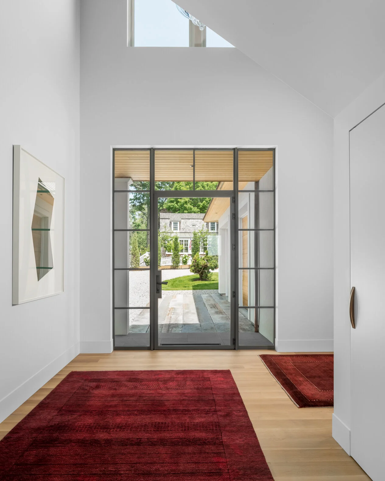 A light-filled entry sequence designed by Lindsey Architects that creates a seamless connection between interior and exterior living spaces. Tall ceilings, expansive steel-framed glass doors, and carefully balanced proportions bring natural light dee