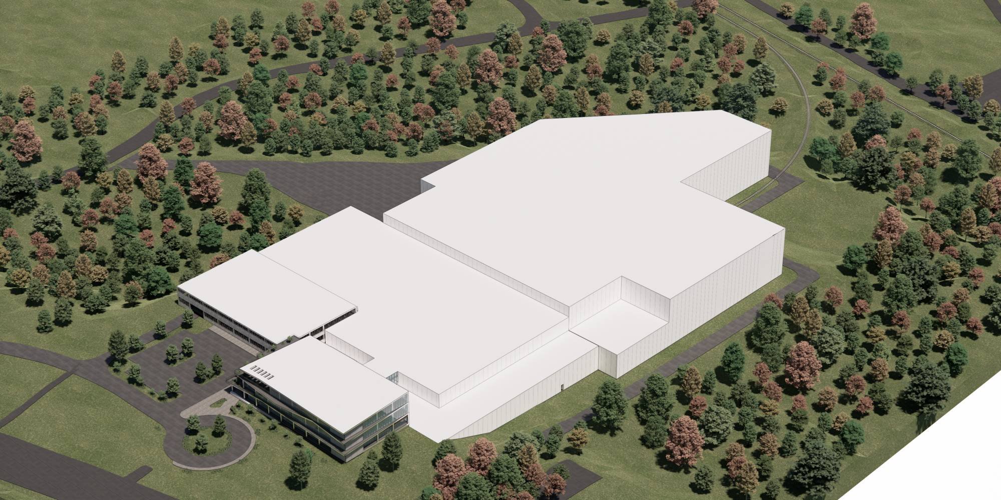 Aerial view of a large industrial building surrounded by trees and greenery, with pathways and driveways visible.