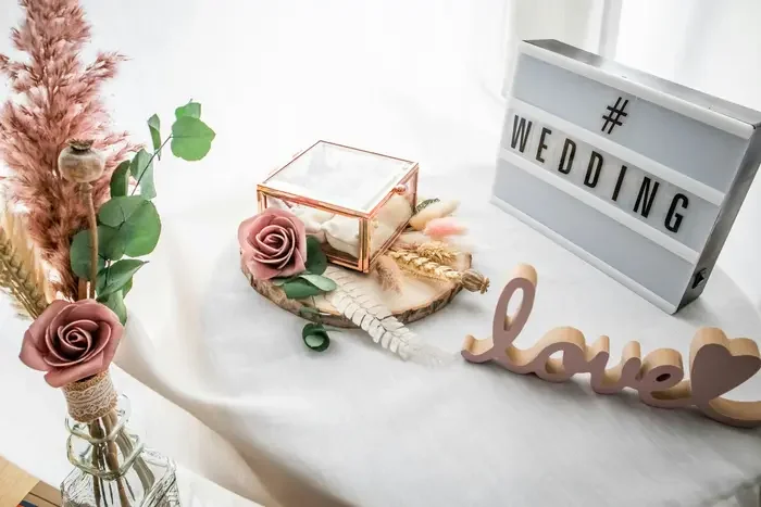 Elegant wedding reception table decorated with flowers and a lightbox sign, the perfect occasion for a wedding video slideshow