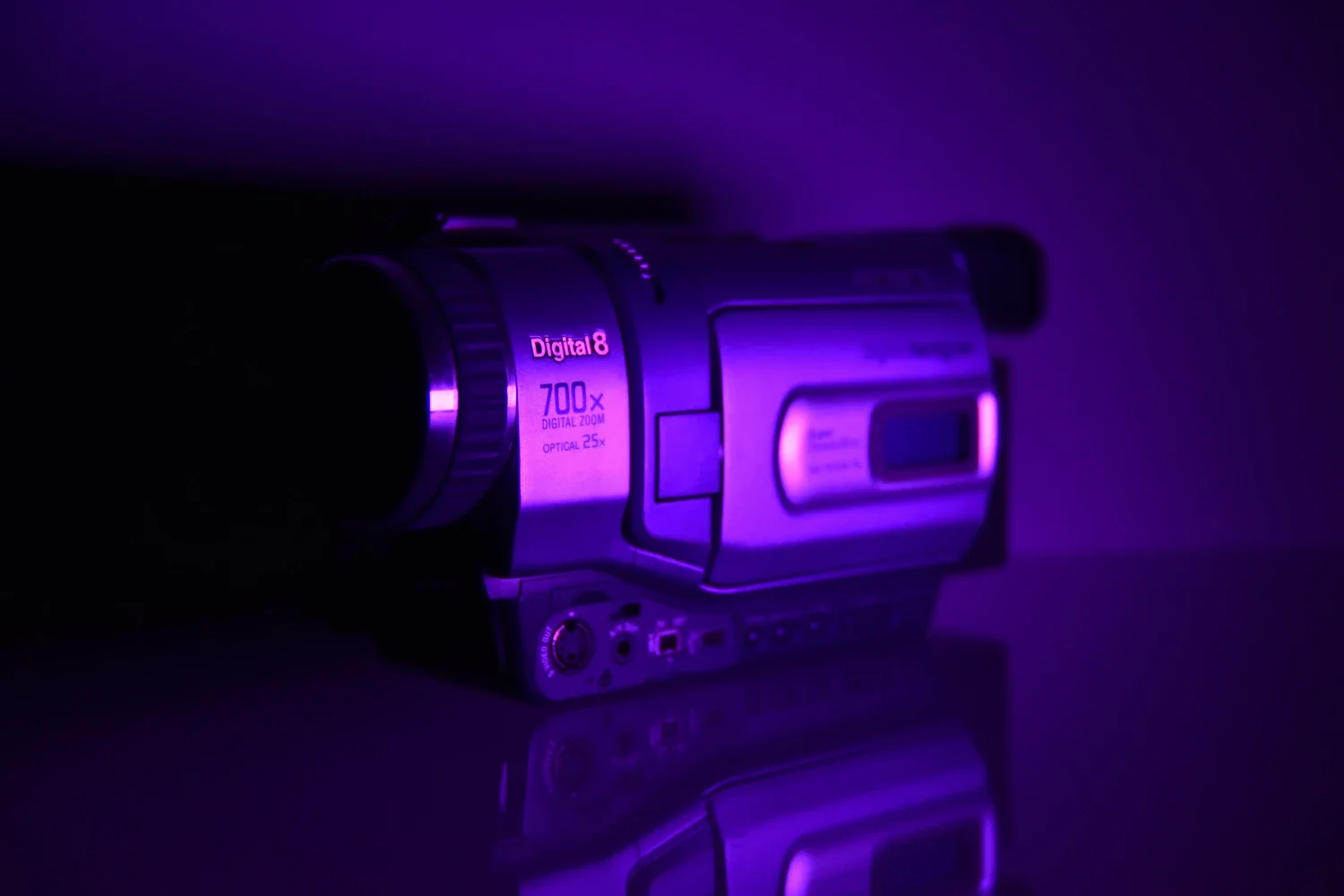 A vintage camcorder with purple lighting, showing a digital zoom of 700x and optical zoom of 25x.