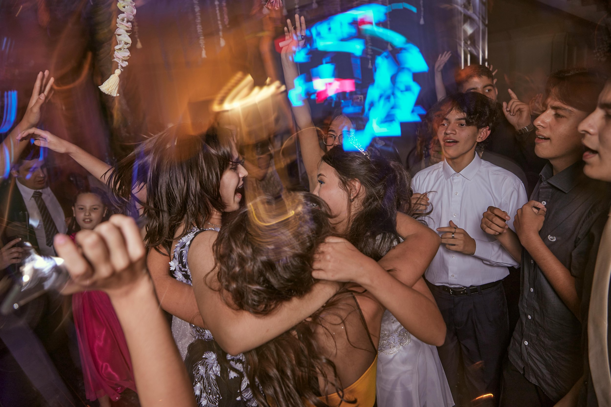 Guests hugging, dancing, and celebrating at a Bat Mitzvah.
