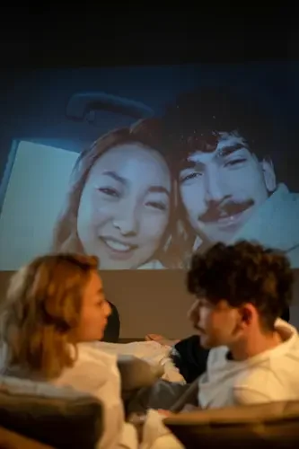 Couple watching their video slideshow displayed on a large screen at a celebration