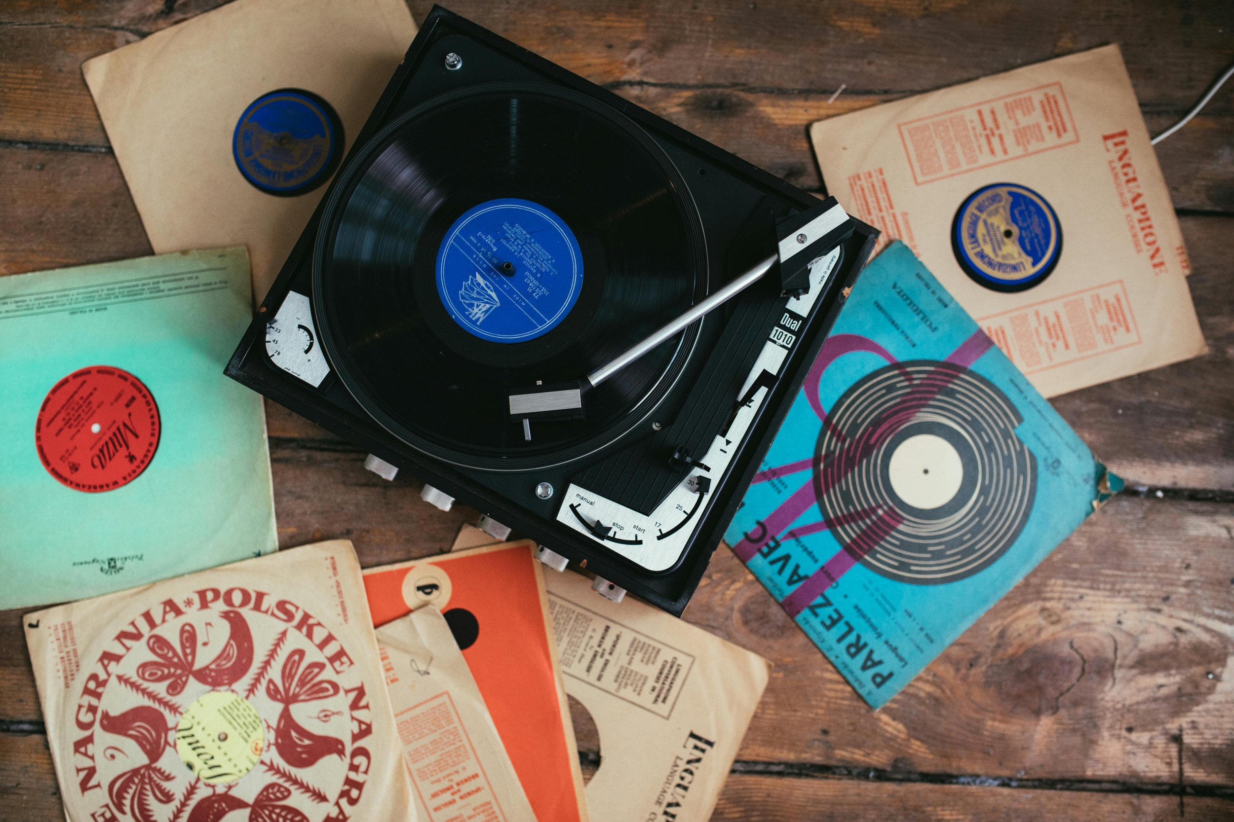 Turntable on floor, vinyl records spread around