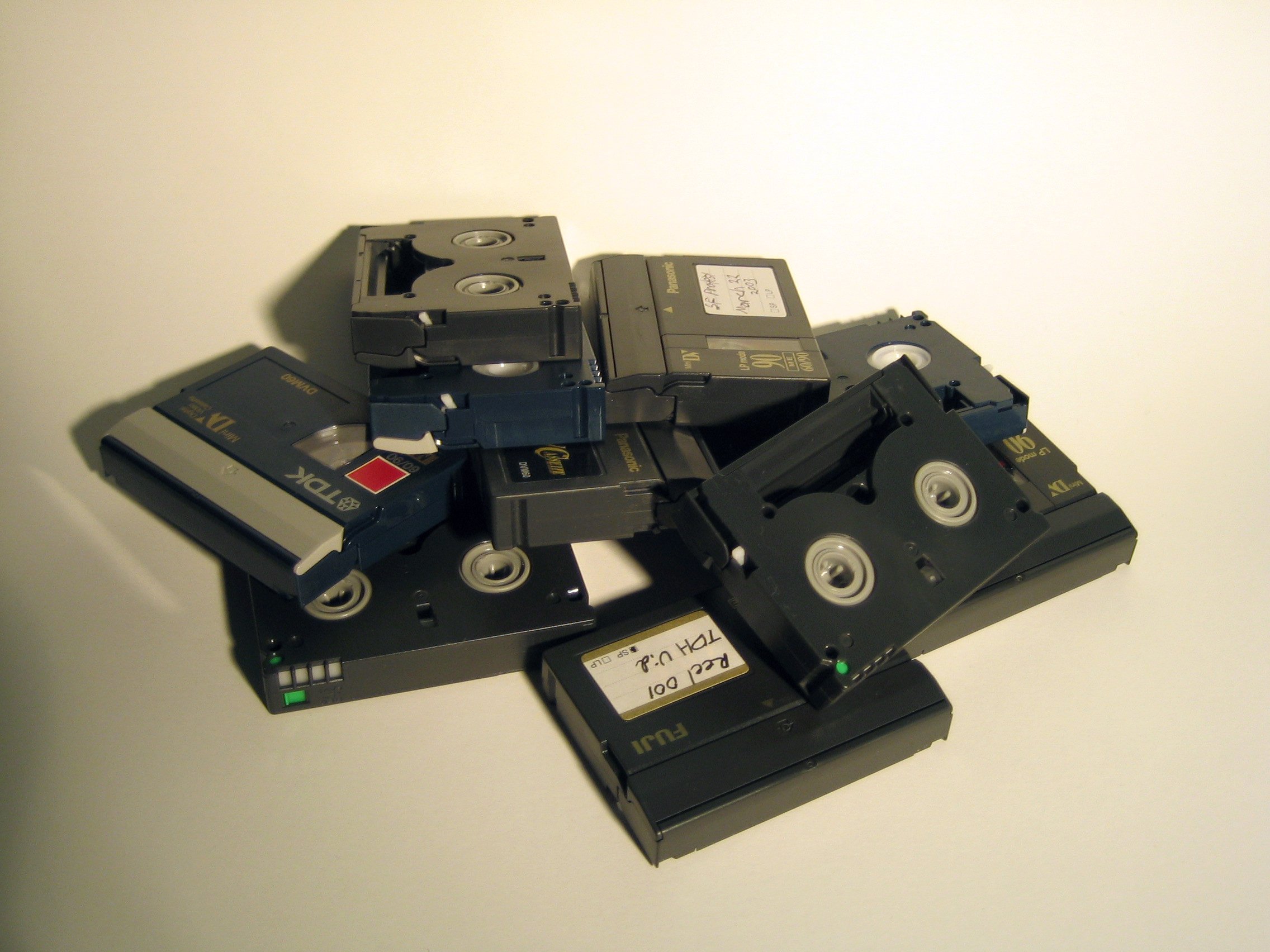 Several mini DV cassettes stacked on a light background.