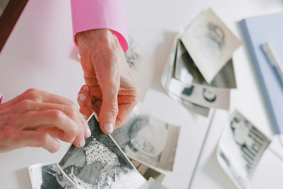A picture of a person's hands sorting through photographs getting them ready to be digitized