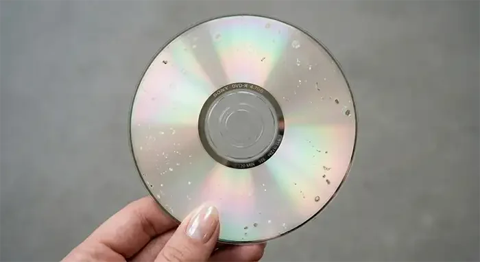 A Sony DVD-R disc showing visible signs of disc rot, with white spots, oxidation marks and surface degradation spread across the reflective layer.