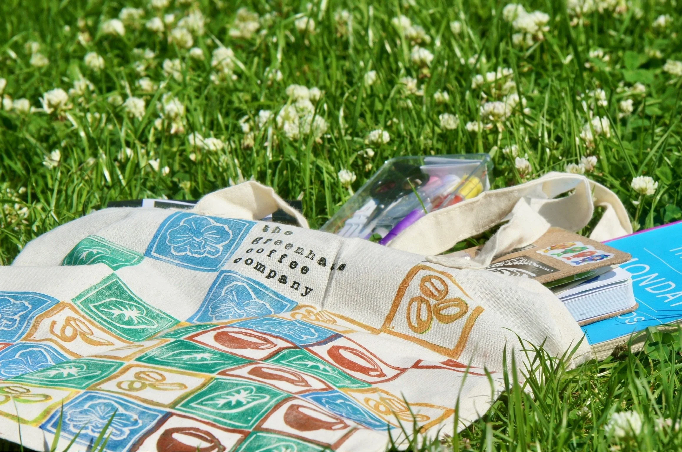 Greenhaus Coffee Co tote bag with botanical design displayed at a coffee cart setup in Naples Florida