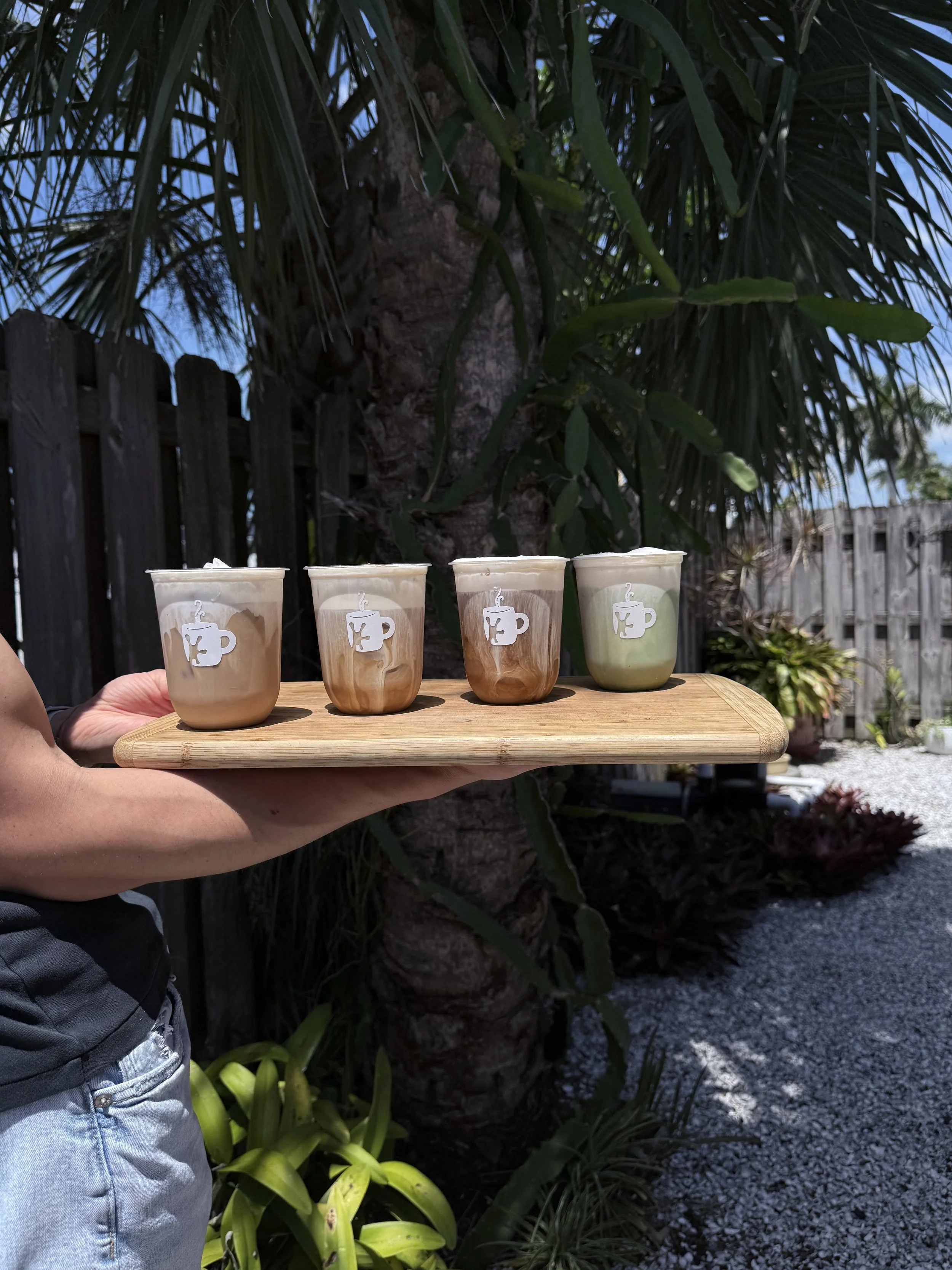 Four handcrafted espresso drinks from Greenhaus Coffee Co served on a board at a coffee catering event in Naples Florida