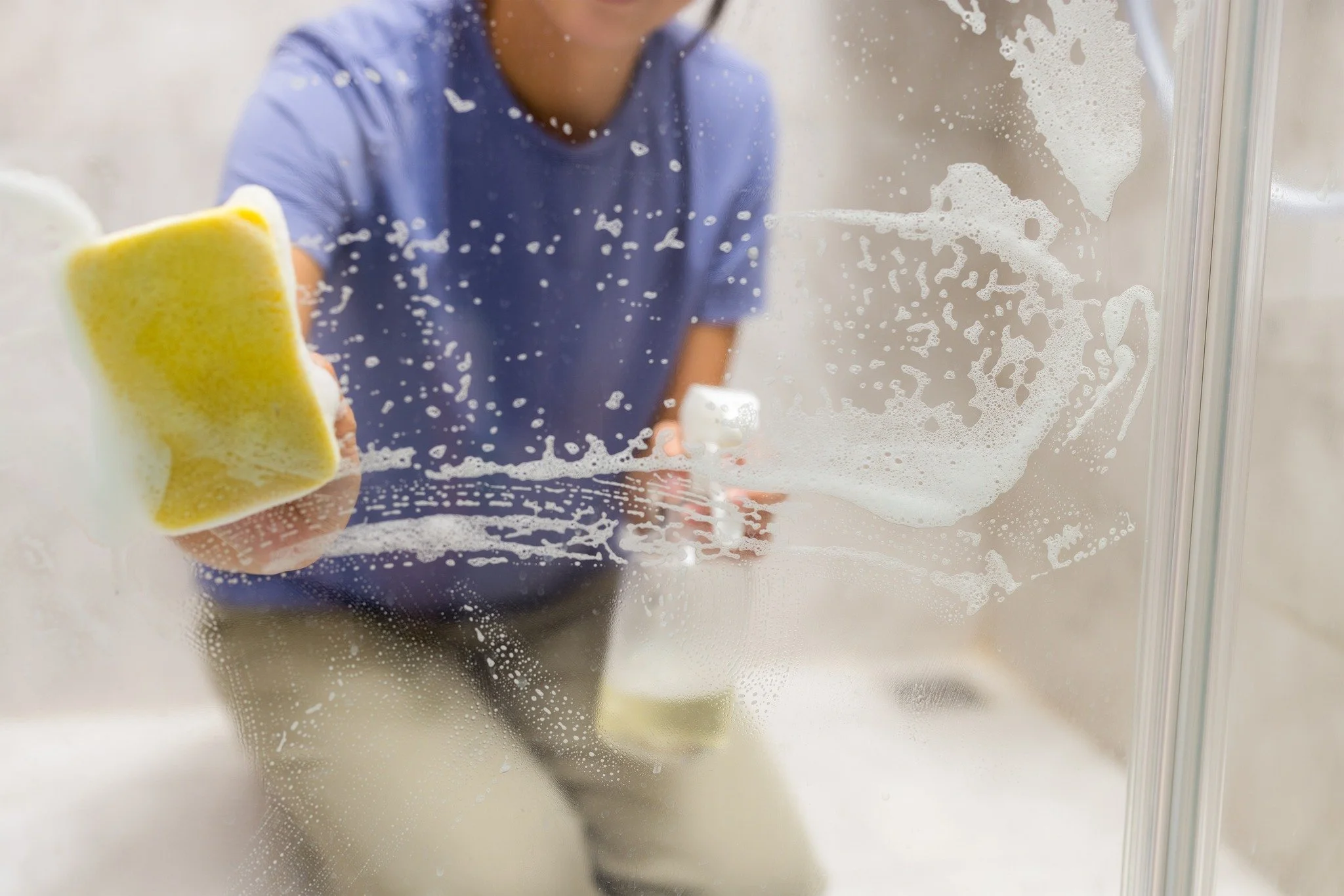Woman cleaning shower glass