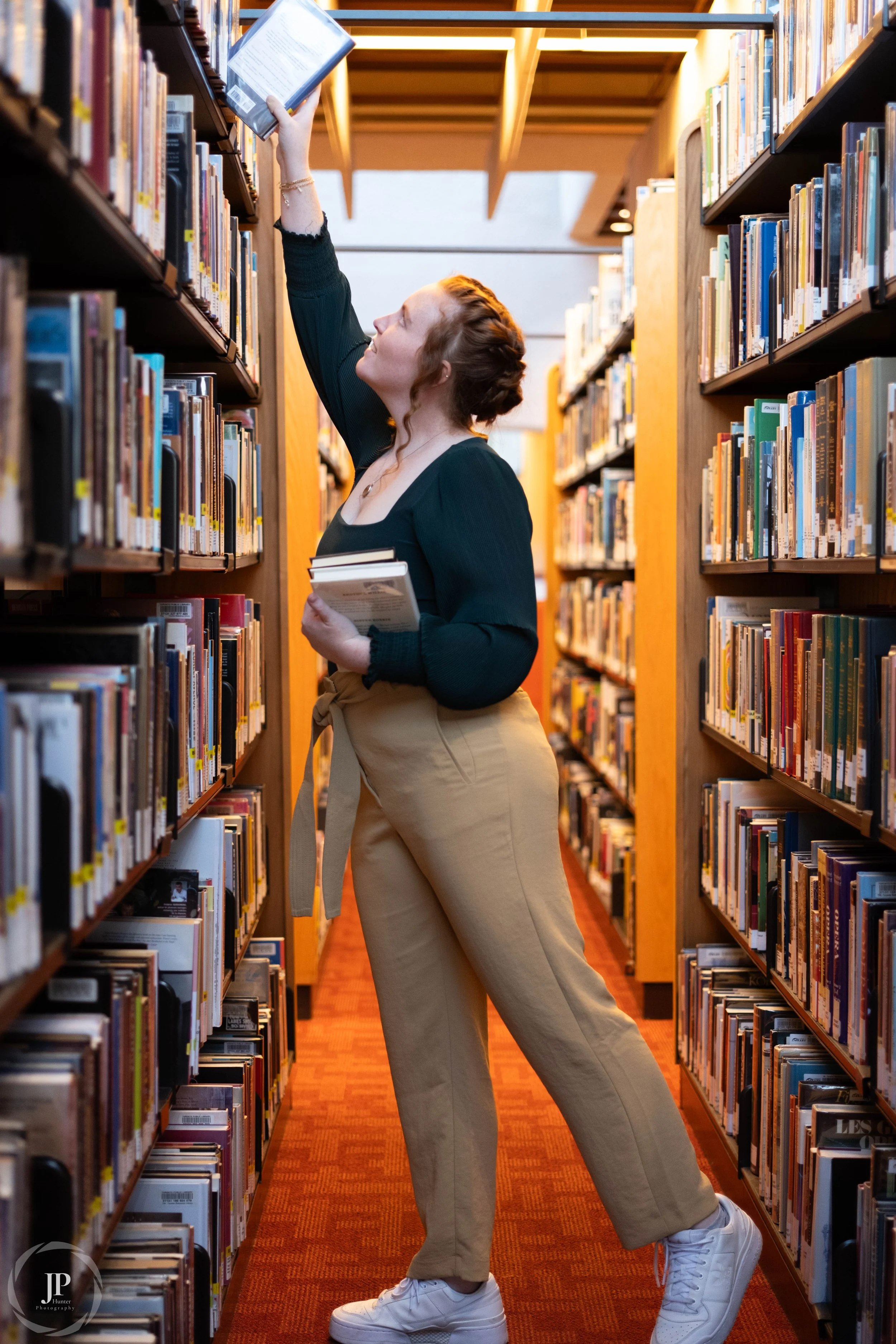 Person reaching for a book in a library
