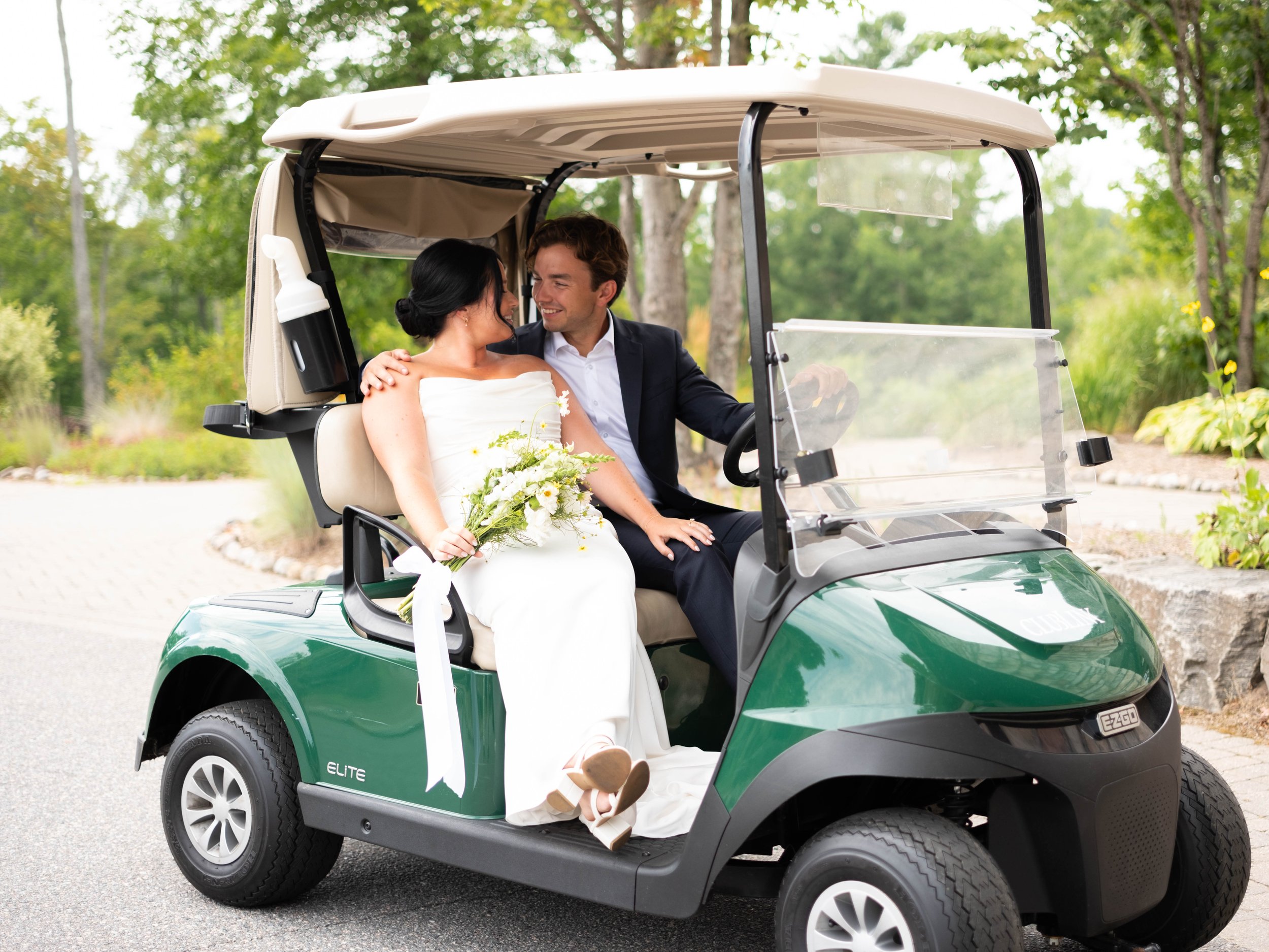 A married couple sitting on a golf cart looking lovingly into their eyes