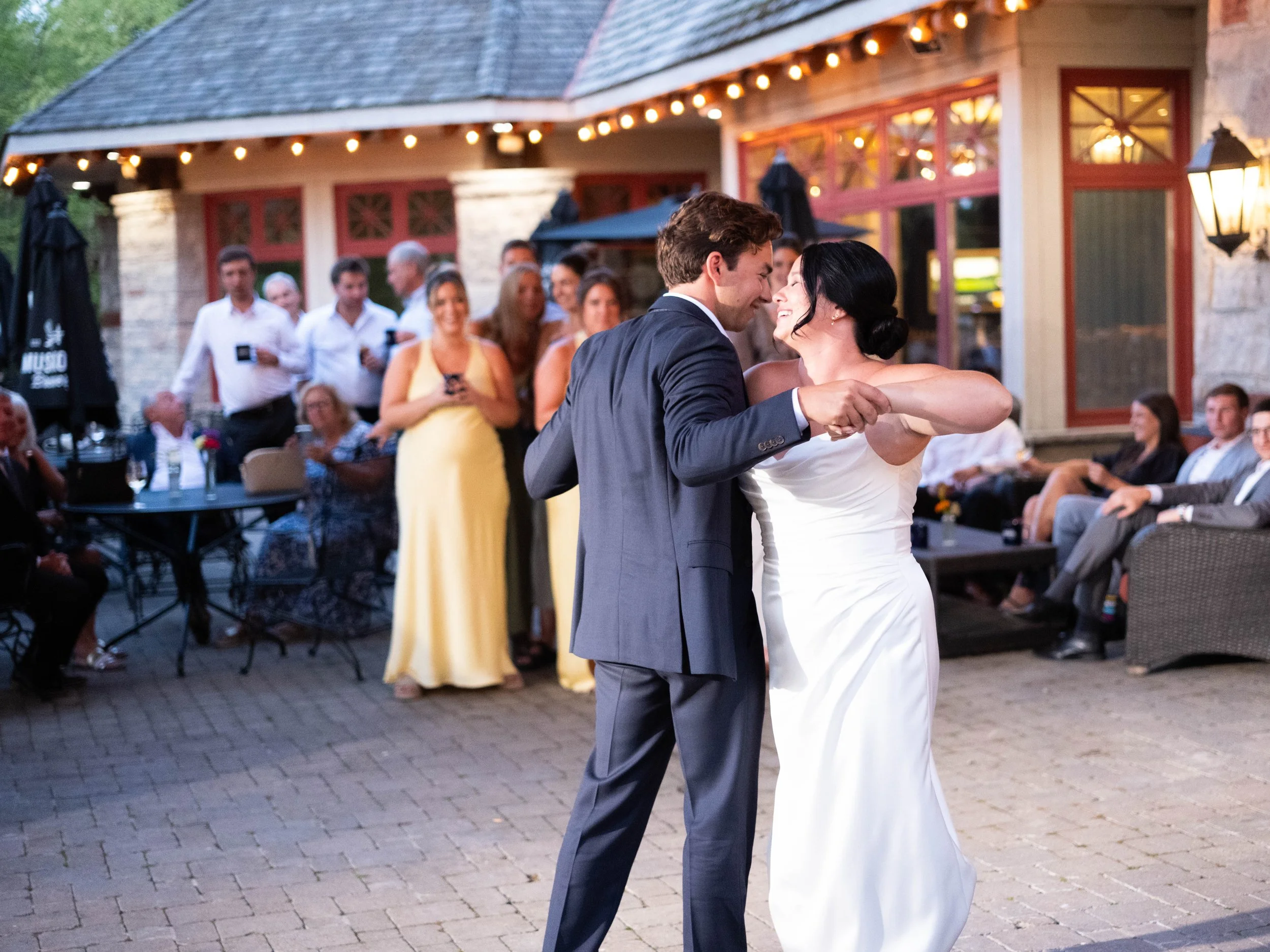 The first dance between a bride and groom with their family and friends cheering them on in the background