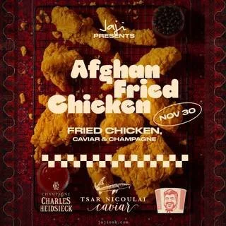 Gourmet dish on a blue plate with sauce being poured, garnished with greens and accompanied by an orange wedge.