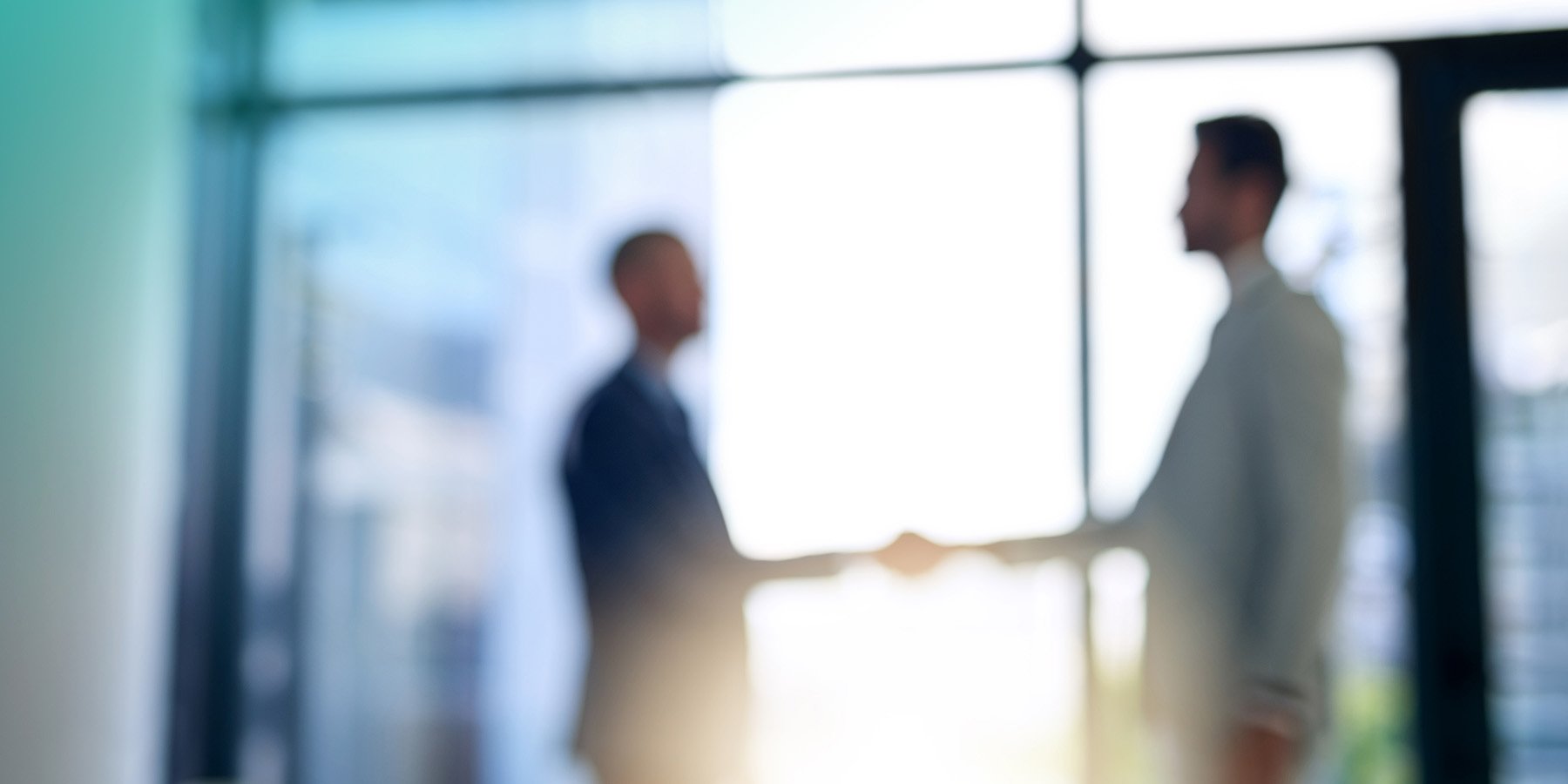 Blurred shot of two people shaking hands in an office