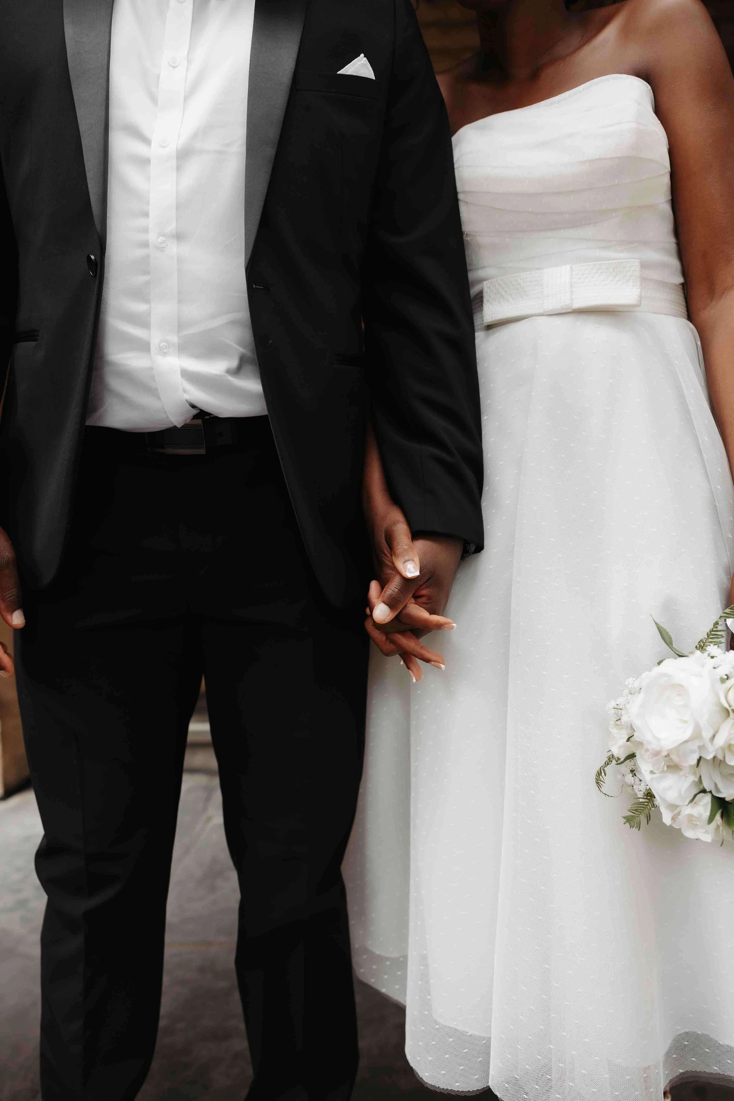 A bride and groom walk hand-in-hand in front of the Adelaide Art Gallery. Captured by Woodley Photography, an Adelaide Wedding Photographer.