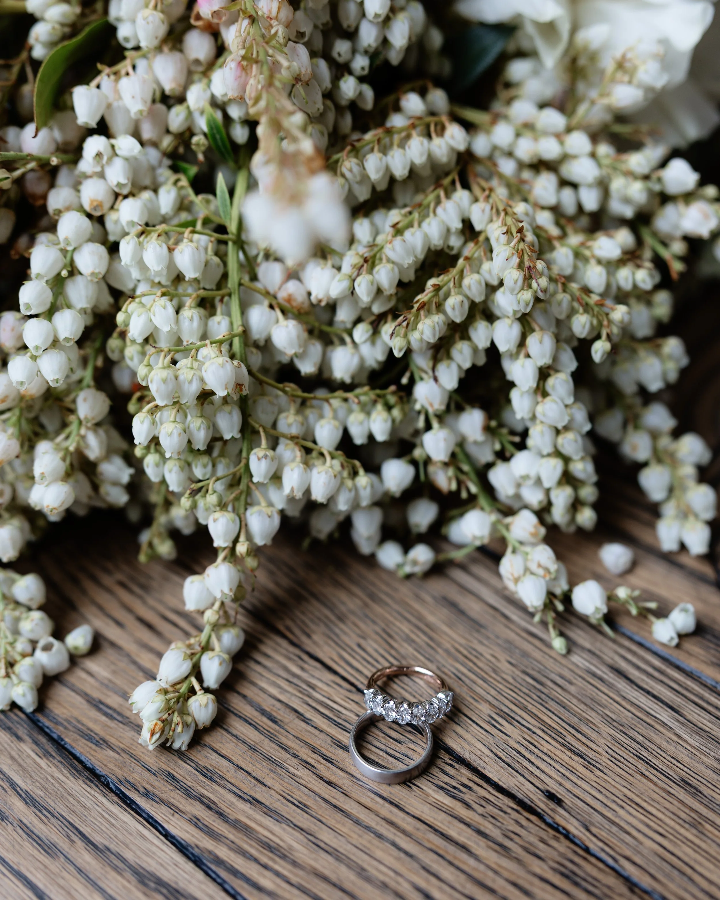 Wedding rings designed by Thredgold jewellers with white and green flowers.