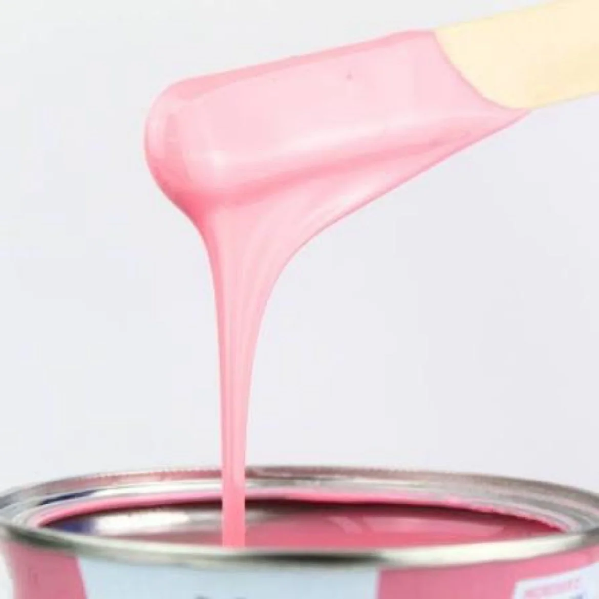Pink wax dripping from a spatula