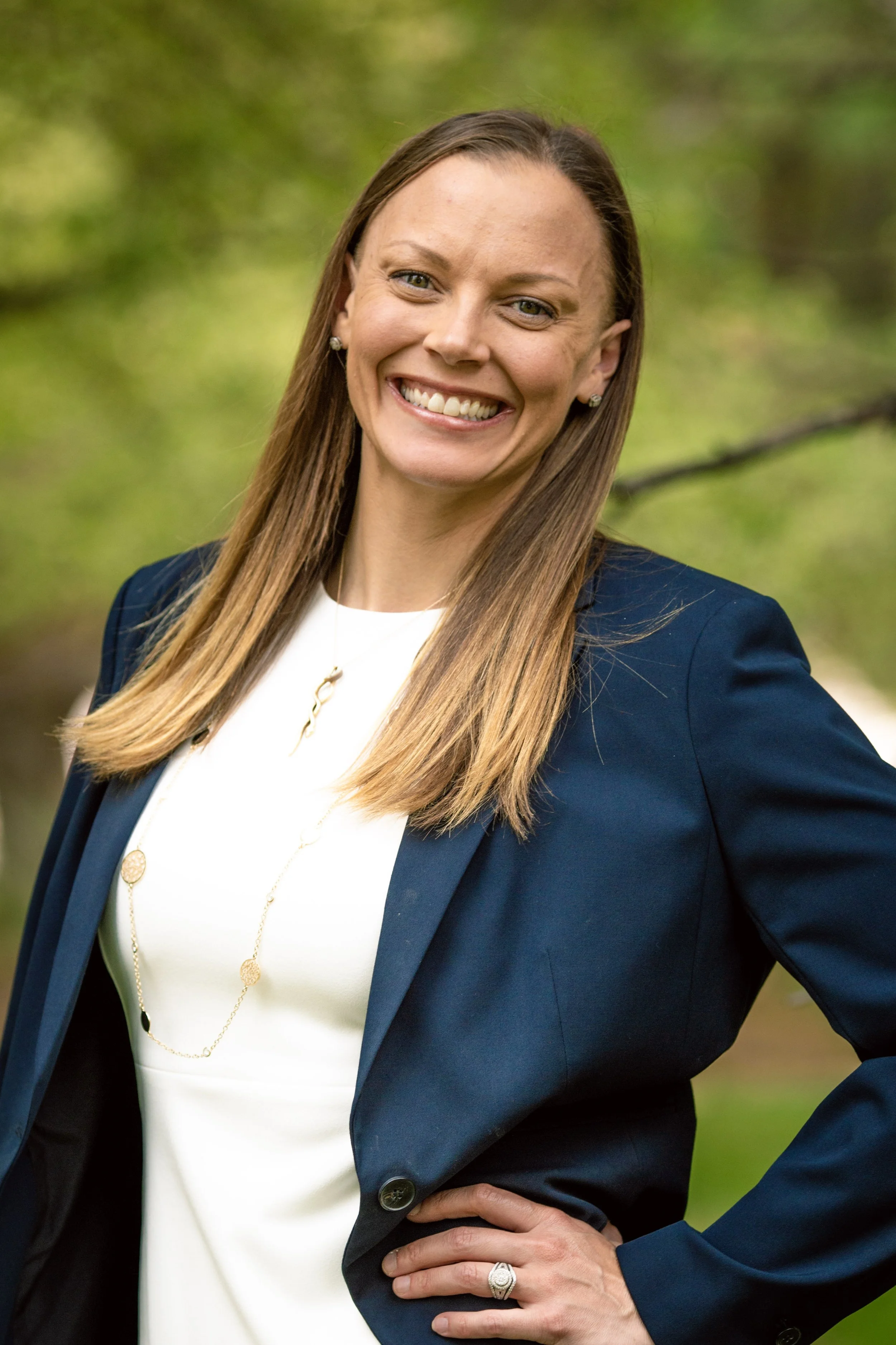 A headshot of Jamie Paine, a white woman with blonde hair wearing a black blazer and white blouse.