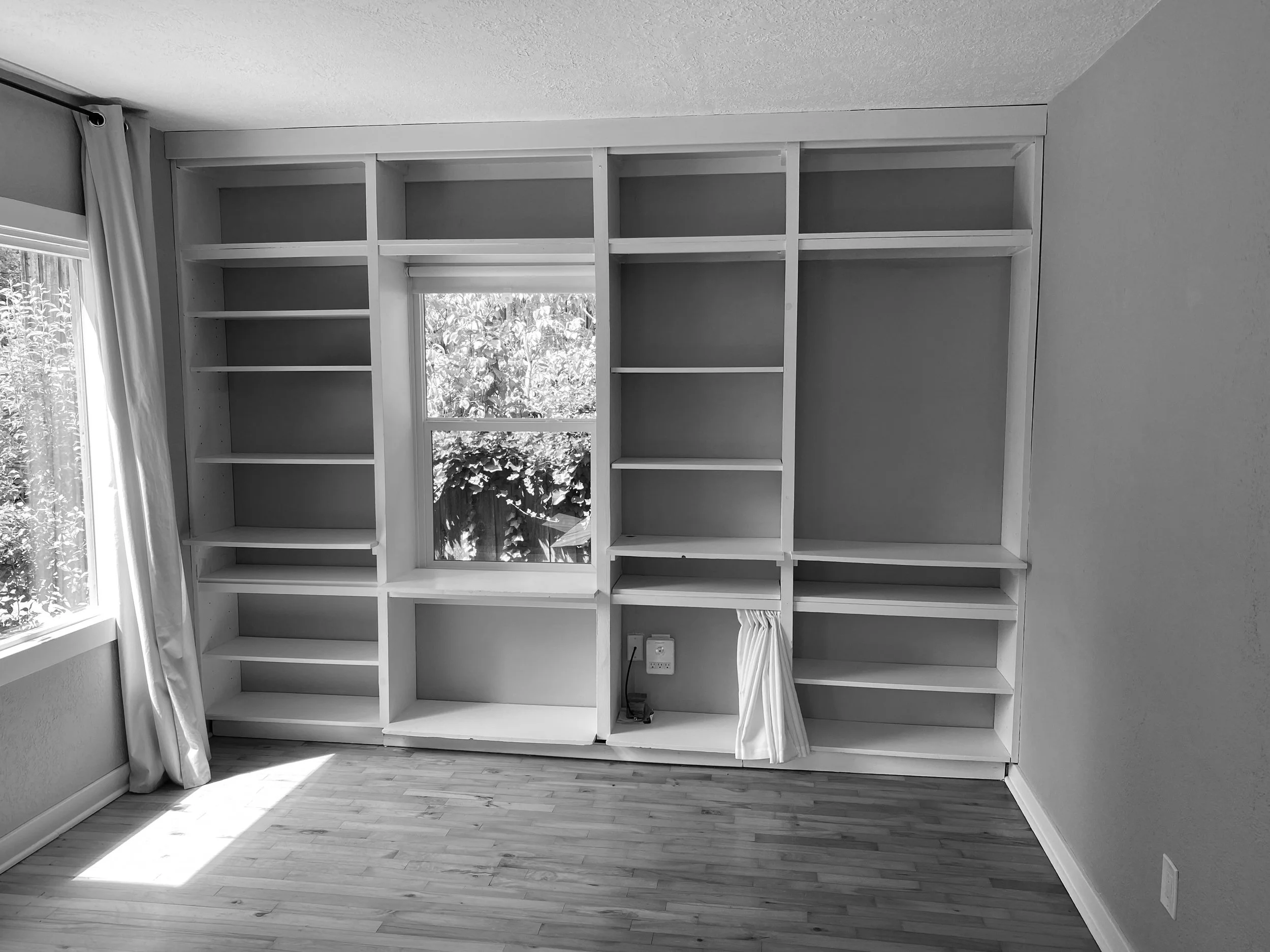 Empty room with built-in shelves and window
