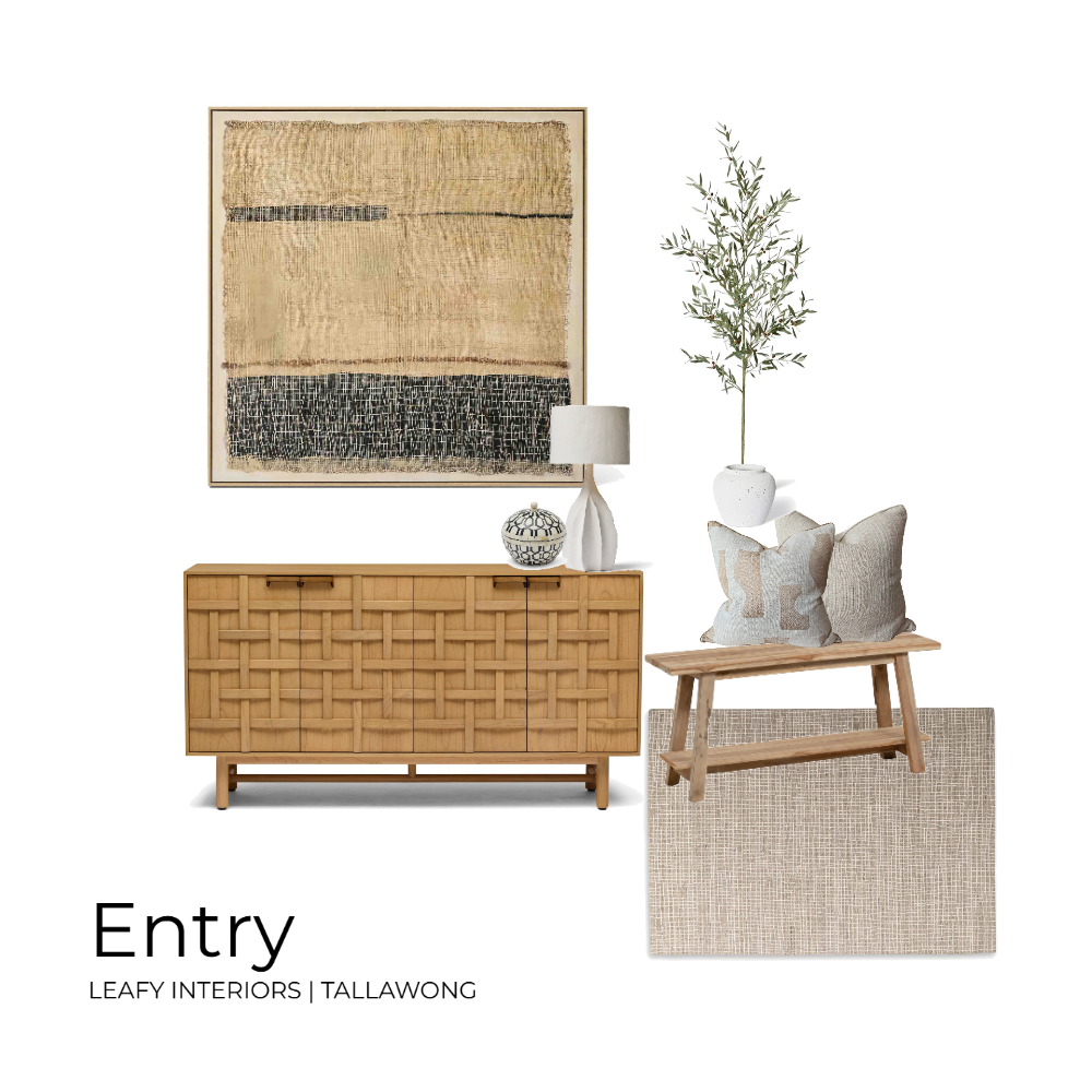 Interior design image of an entryway with a wooden sideboard, a decorative table lamp, a patterned vase, a tall vase with greenery, and a bench with cushions and a rug beneath.
