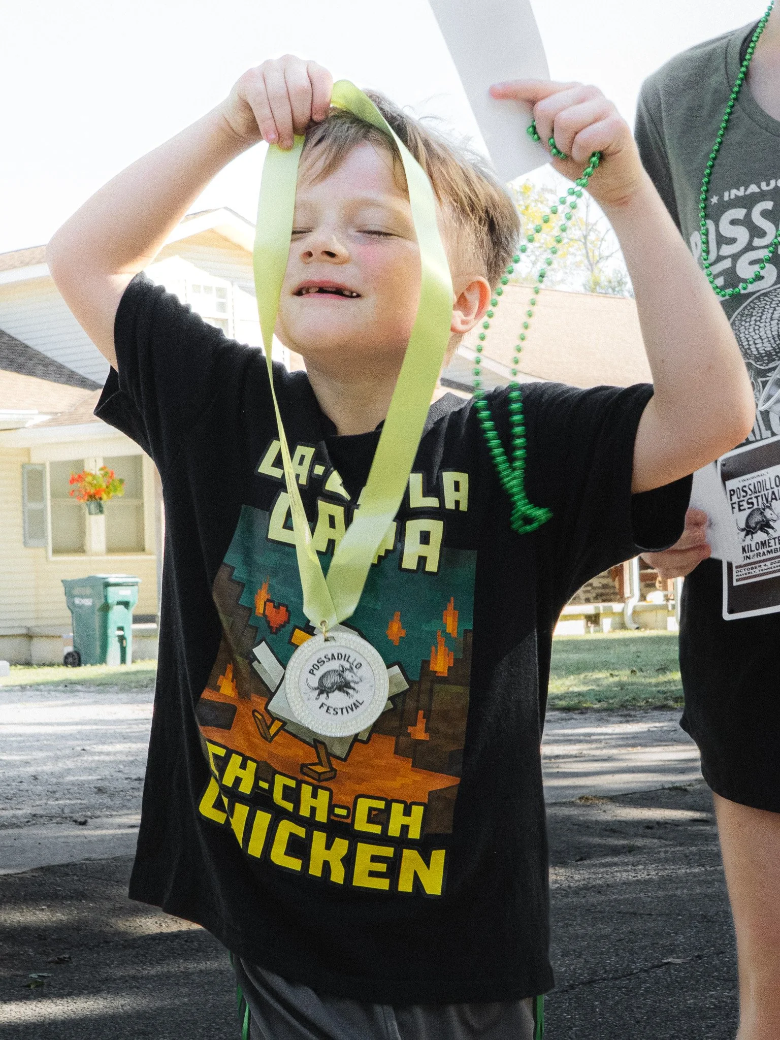 Child with a medal around their neck, celebrating at the Possadillo Festival
