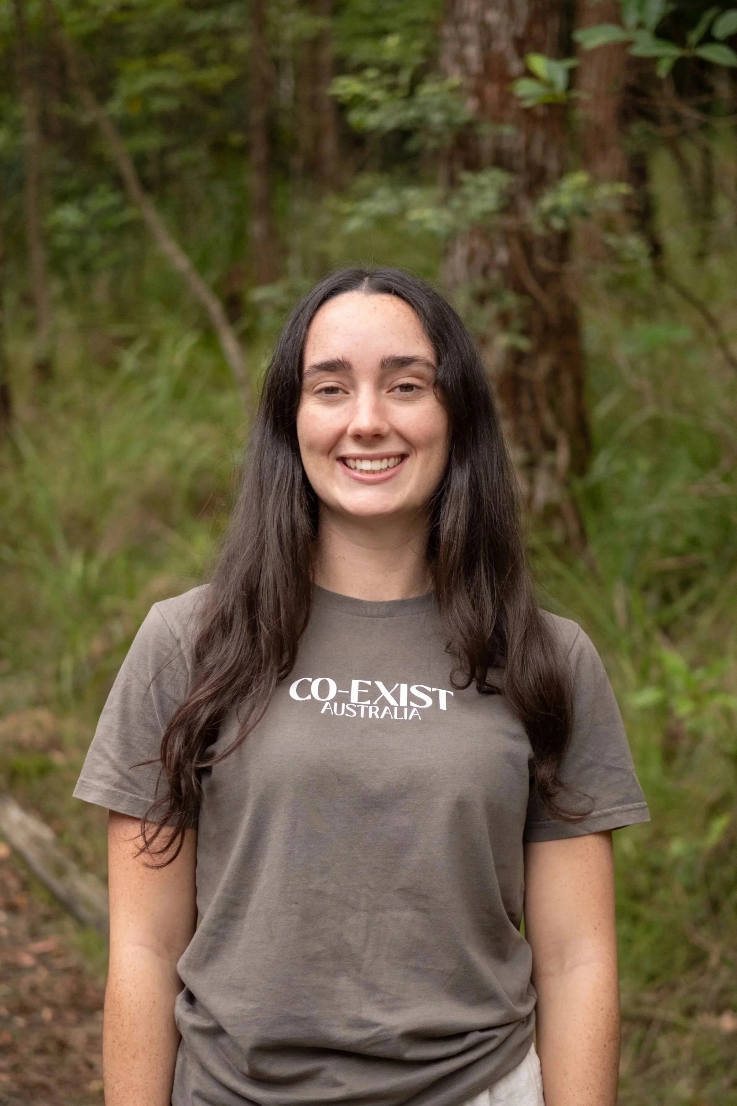 Portrait of a person with curly hair smiling.