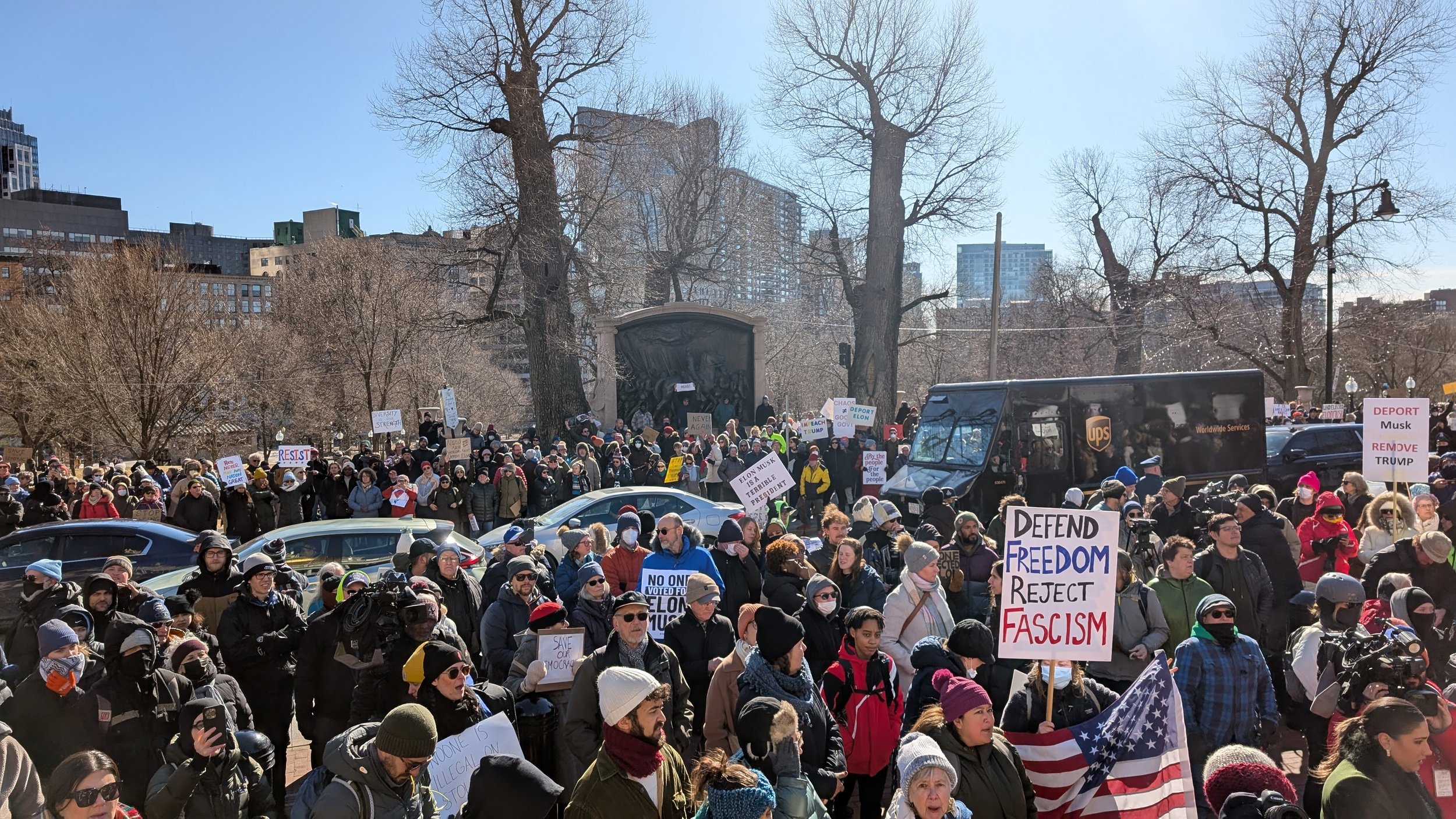 Hundreds of protestors on Boston Common holding signs saying "Defend Freedom Reject Fascism" and "Deport Musk Remove Trump"