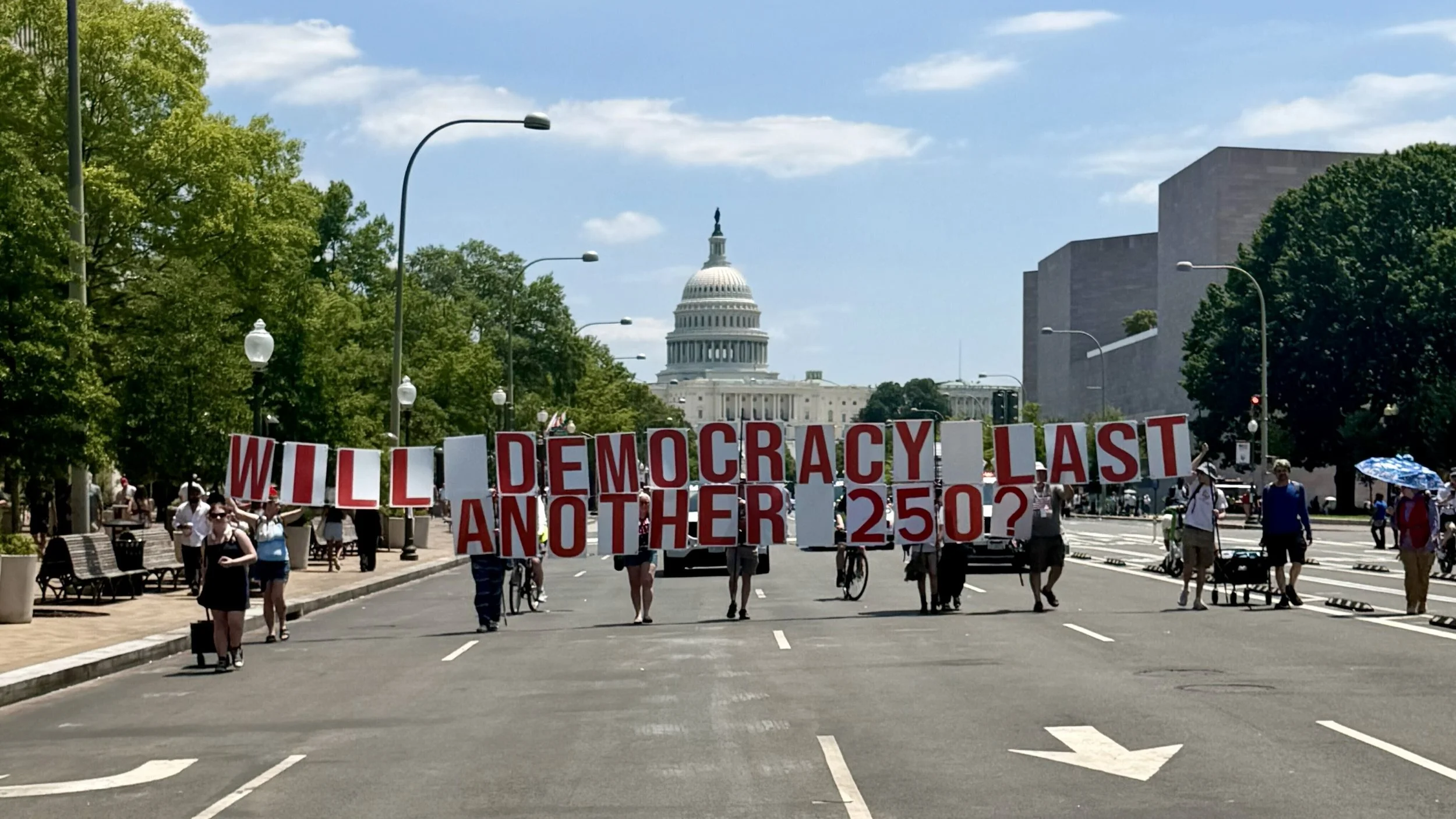 Protestors holding up letters spelling out “Will Democracy Last Another 250?” in front of the U.S. Capitol as part of Seven Days in D.C.