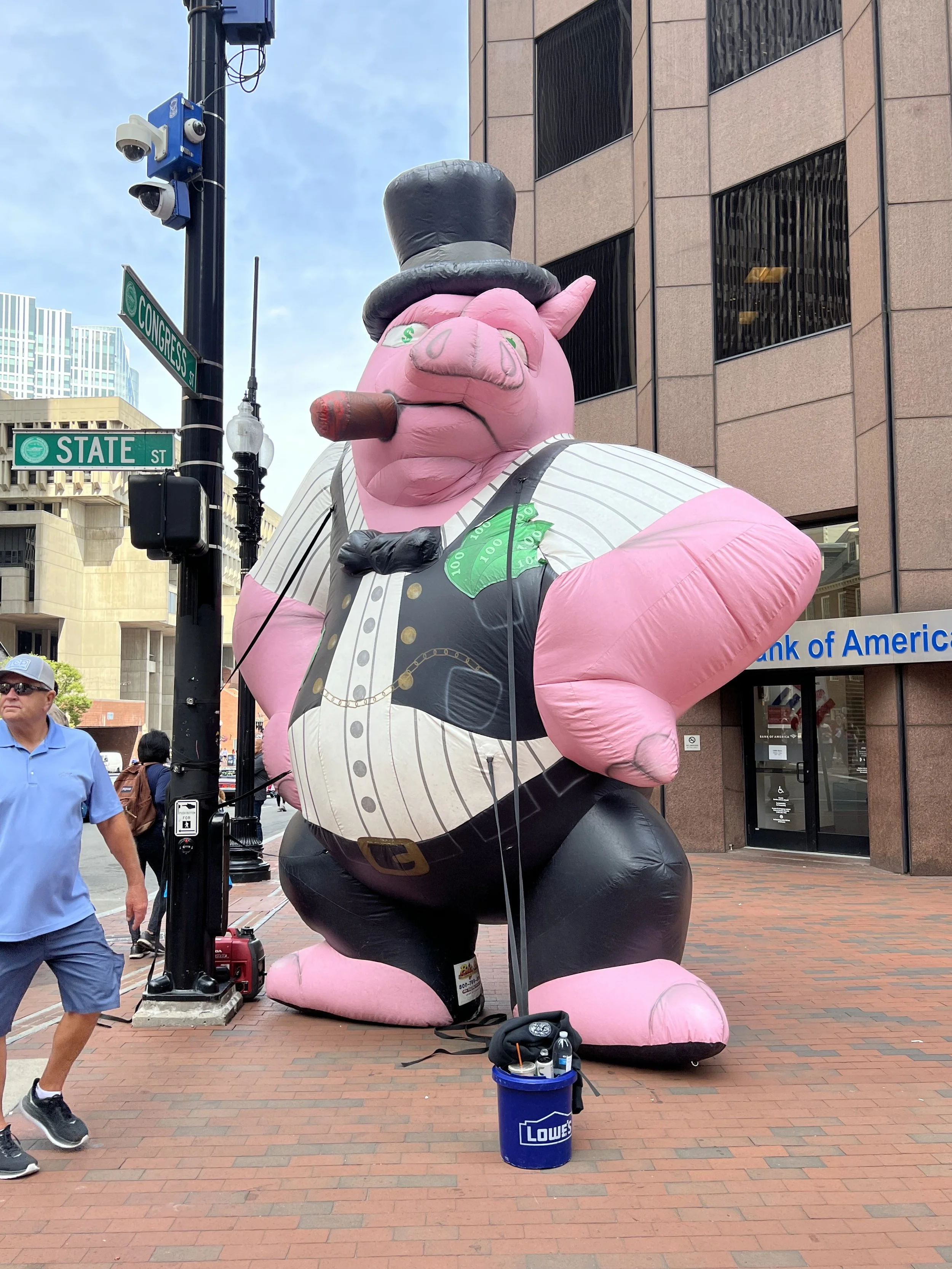a large blow-up figurine depicting a rich pig in a top hat with a cigar and money in his pocket