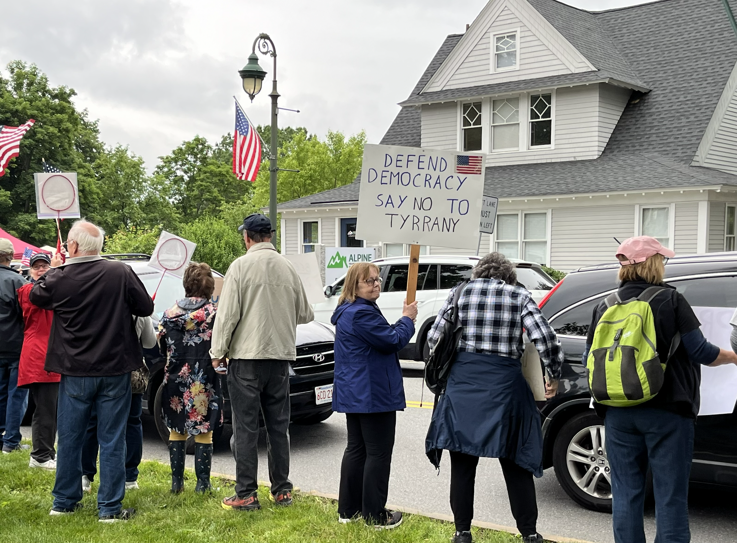 Protestors holding a sign saying "Defend Democracy. Say No to Tyrrany"