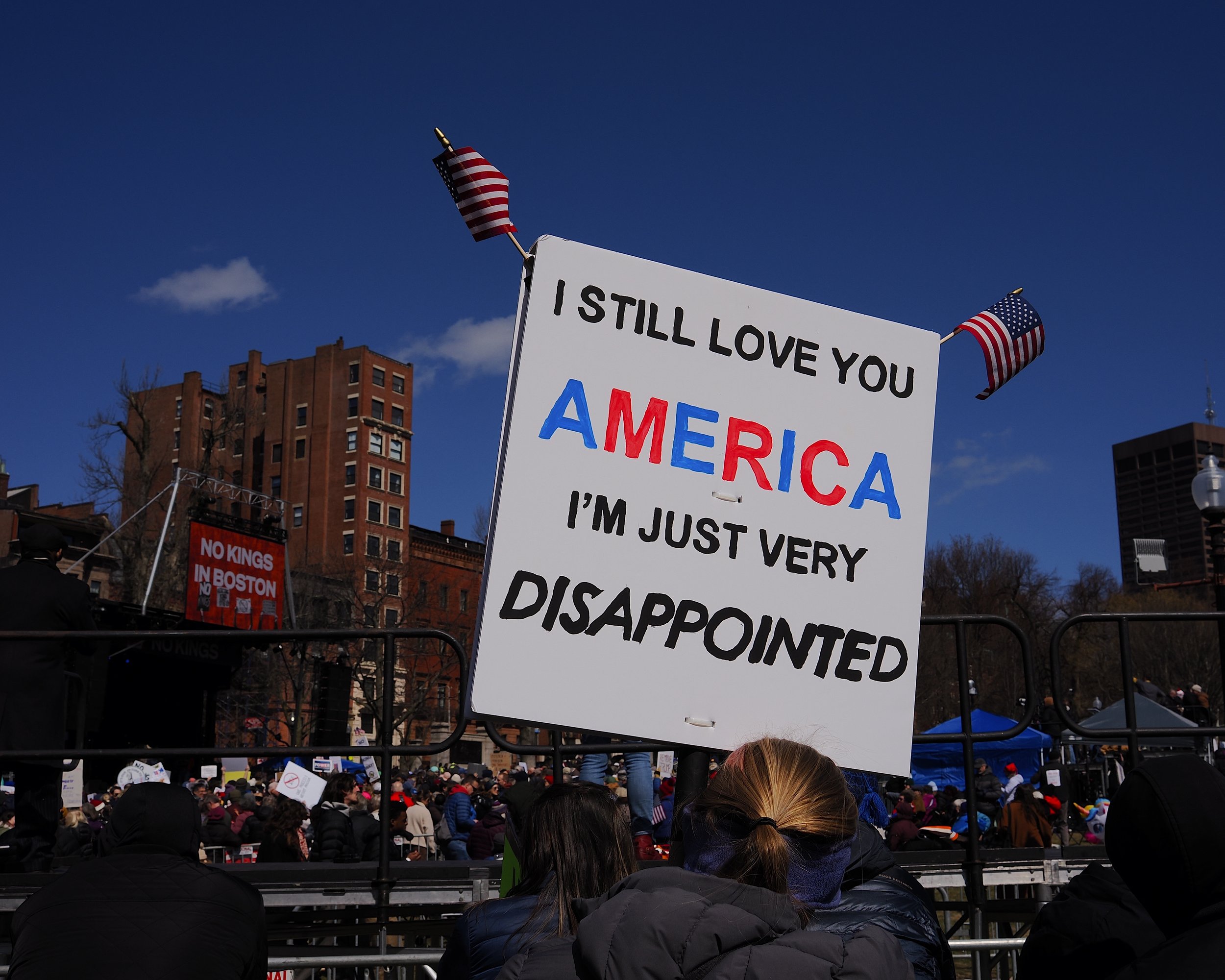 A sign that says "I Still Love you America I'm Just Very Disappointed" at a No Kings protest organized by Massachusetts 50501.