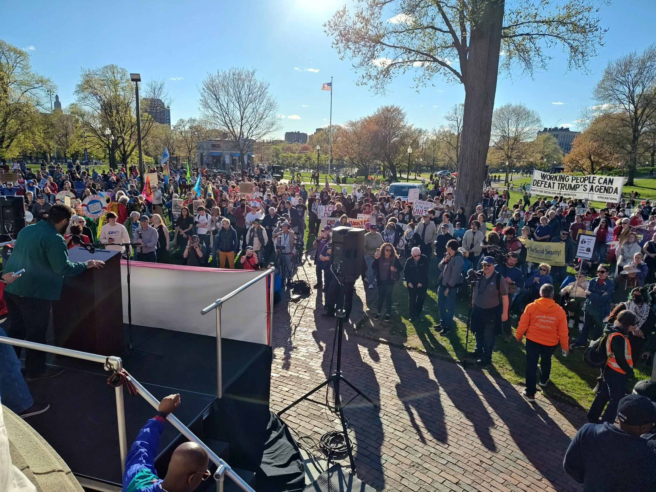 Photo shows a crowd forming on  sunny spring day to listen to speakers on Boston Common