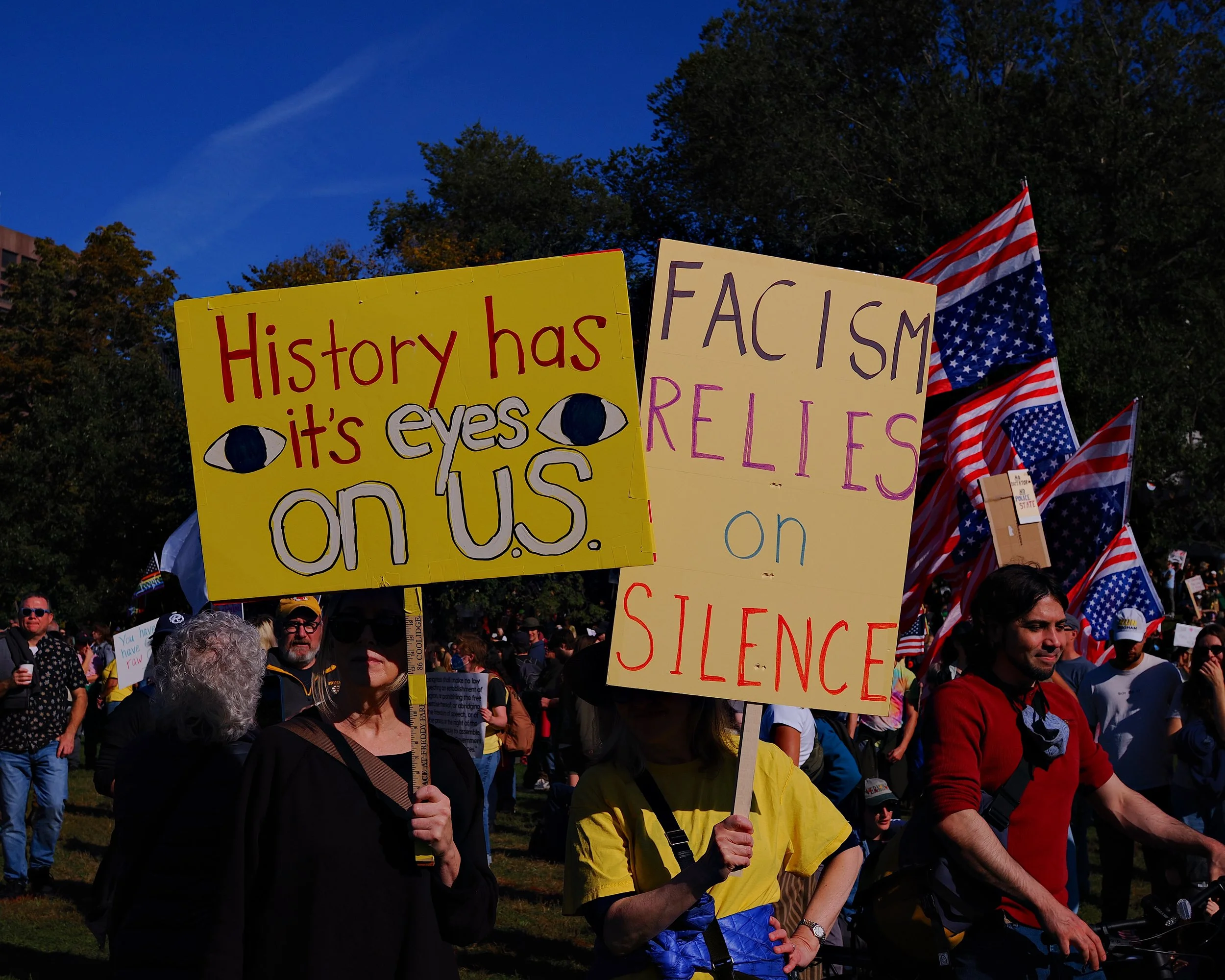 Person holding sign that says "History has its eyes on us" at the No Kings II protest in Boston with Mass 50501.
